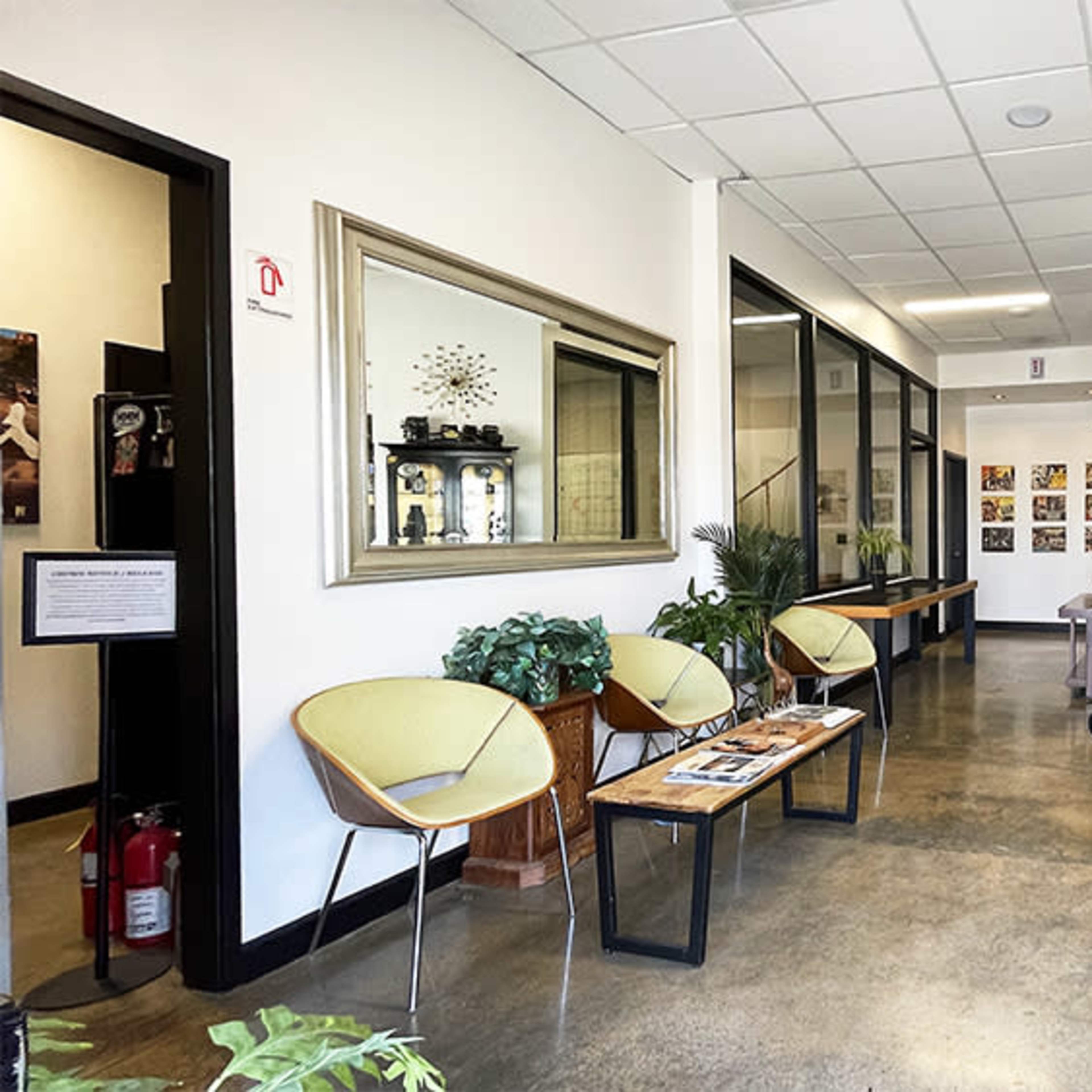 A spacious lobby area with a seating arrangement, artwork on the walls, and a decorative cart in one corner.