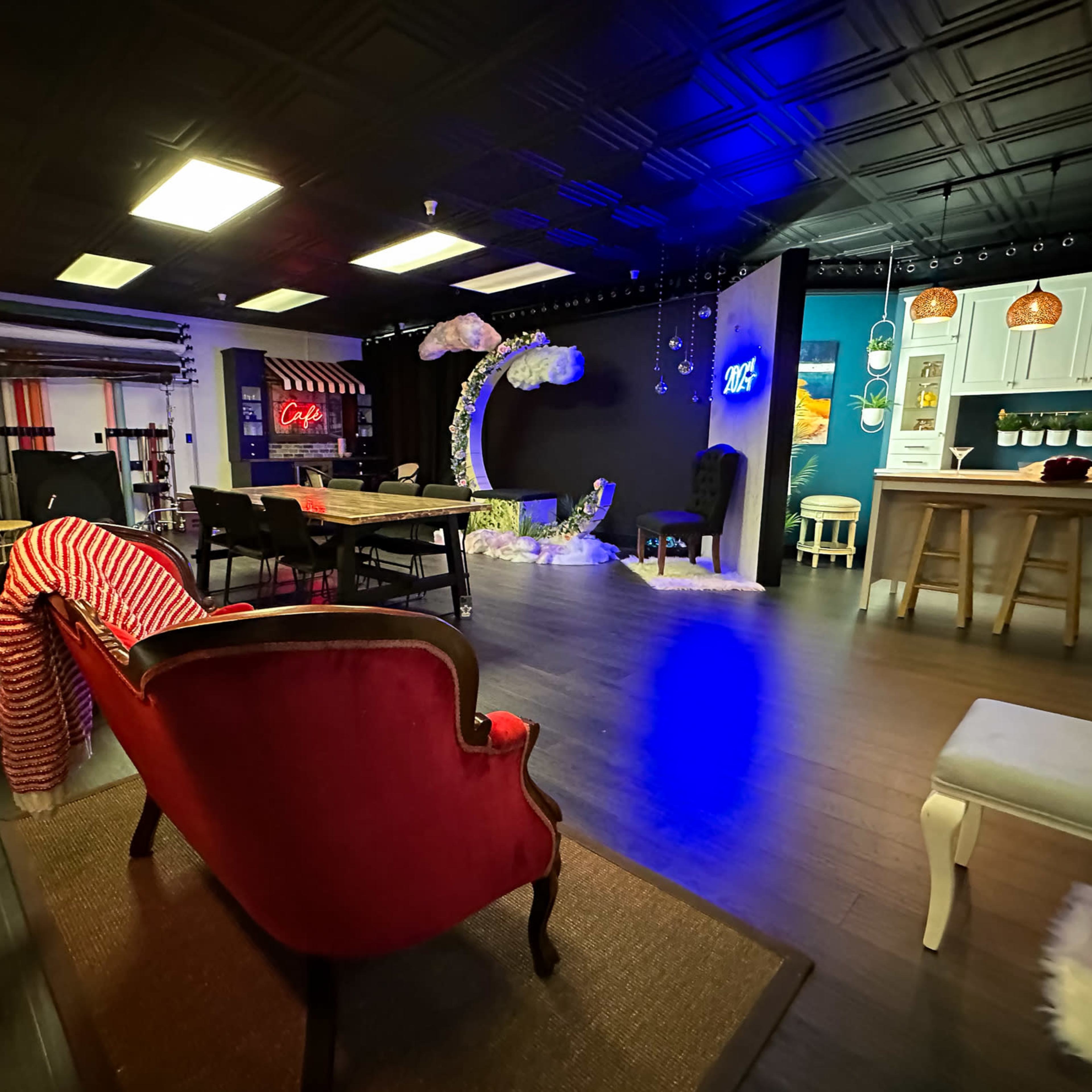 A spacious creative studio with a mix of seating areas, decorative elements, and various light fixtures.