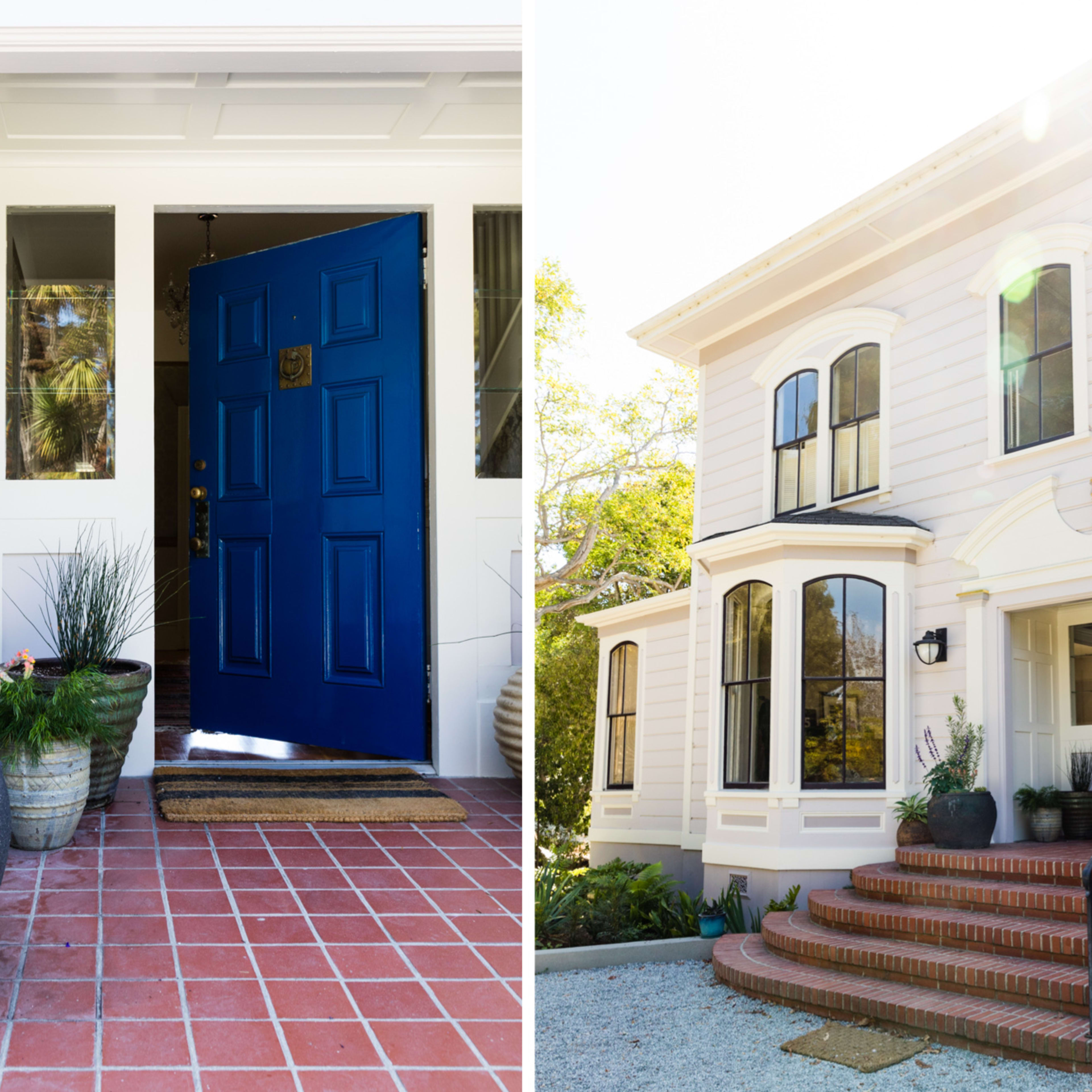 A bright blue front door leading into a home, accompanied by potted plants on a brick pathway, with a view of a large, two-story house that features multiple windows and a staircase.