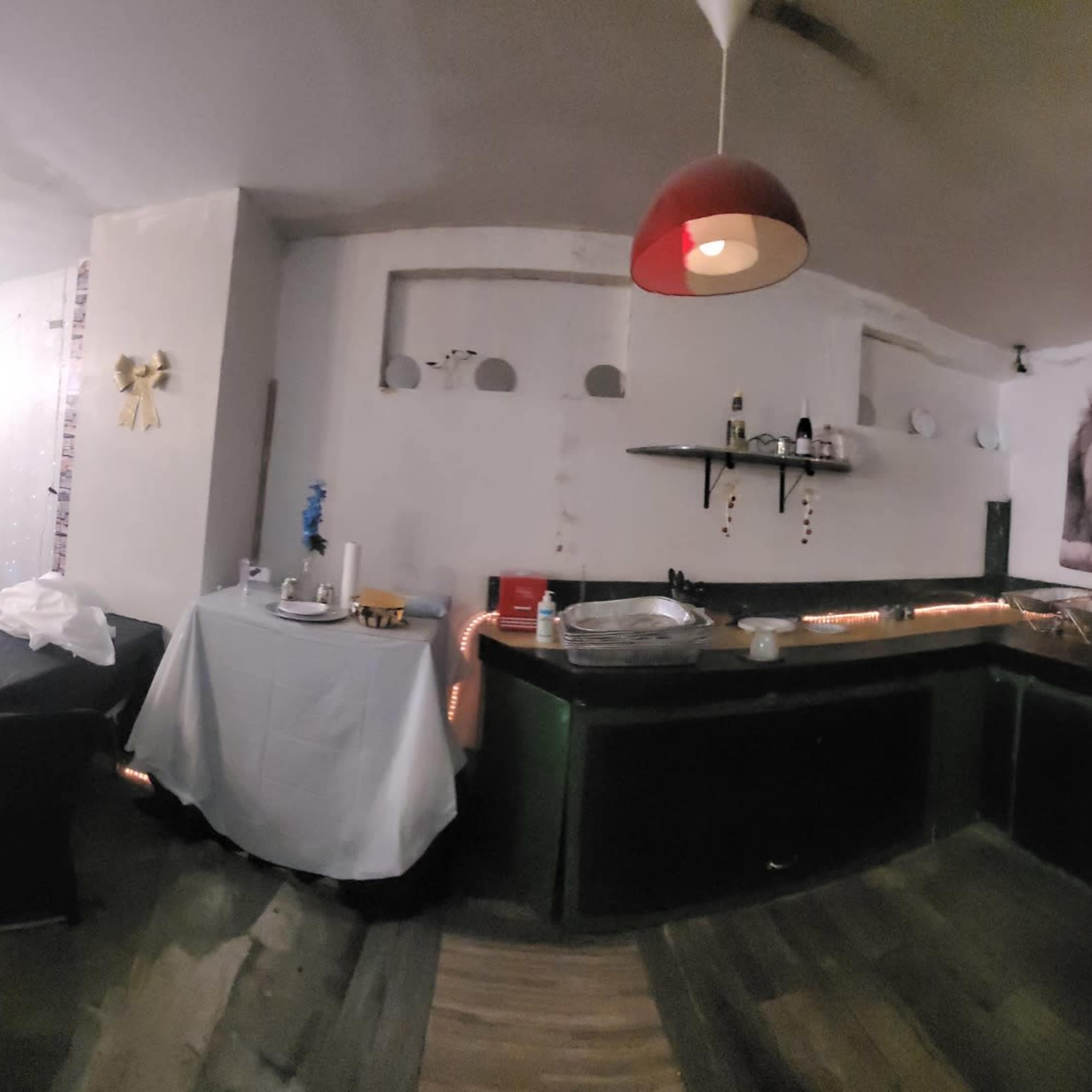 A spacious lounge area with tables, chairs, and food stations, featuring decorative lighting and wall art.