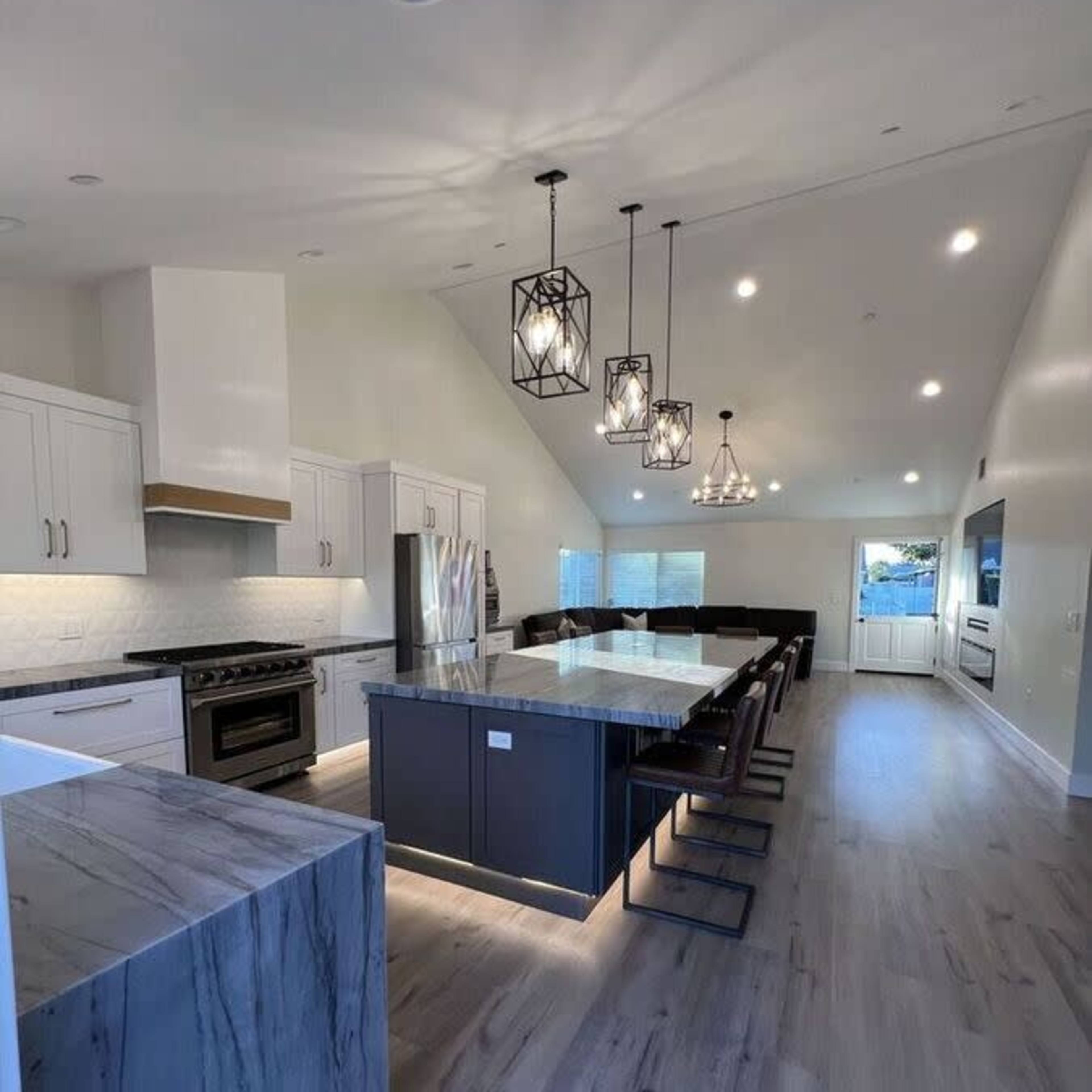 A modern kitchen featuring a large island with seating, stainless steel appliances, and pendant lighting that illuminates the space.