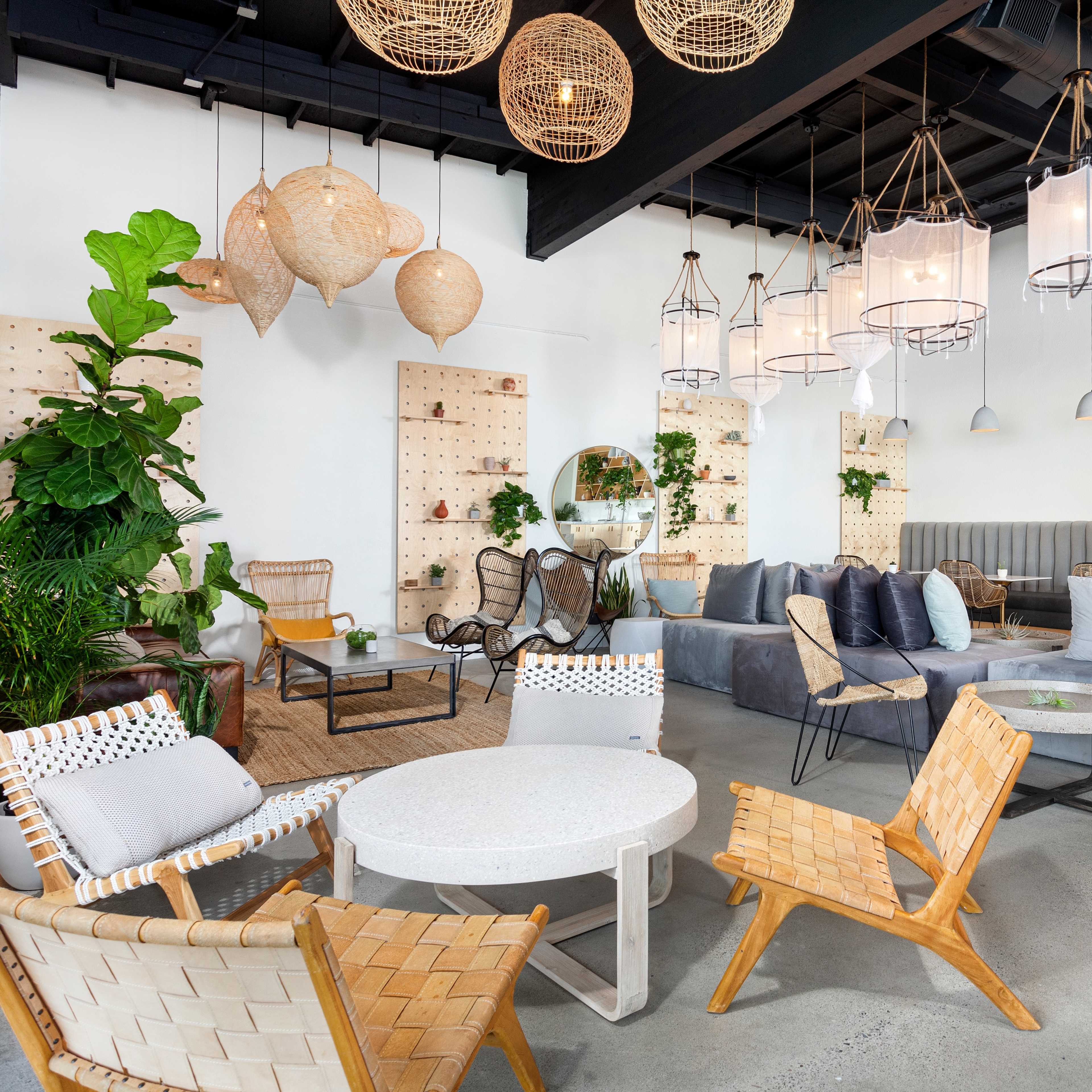A modern lounge area with various seating options, pendant lights, and wall-mounted planters, creating a relaxed atmosphere.