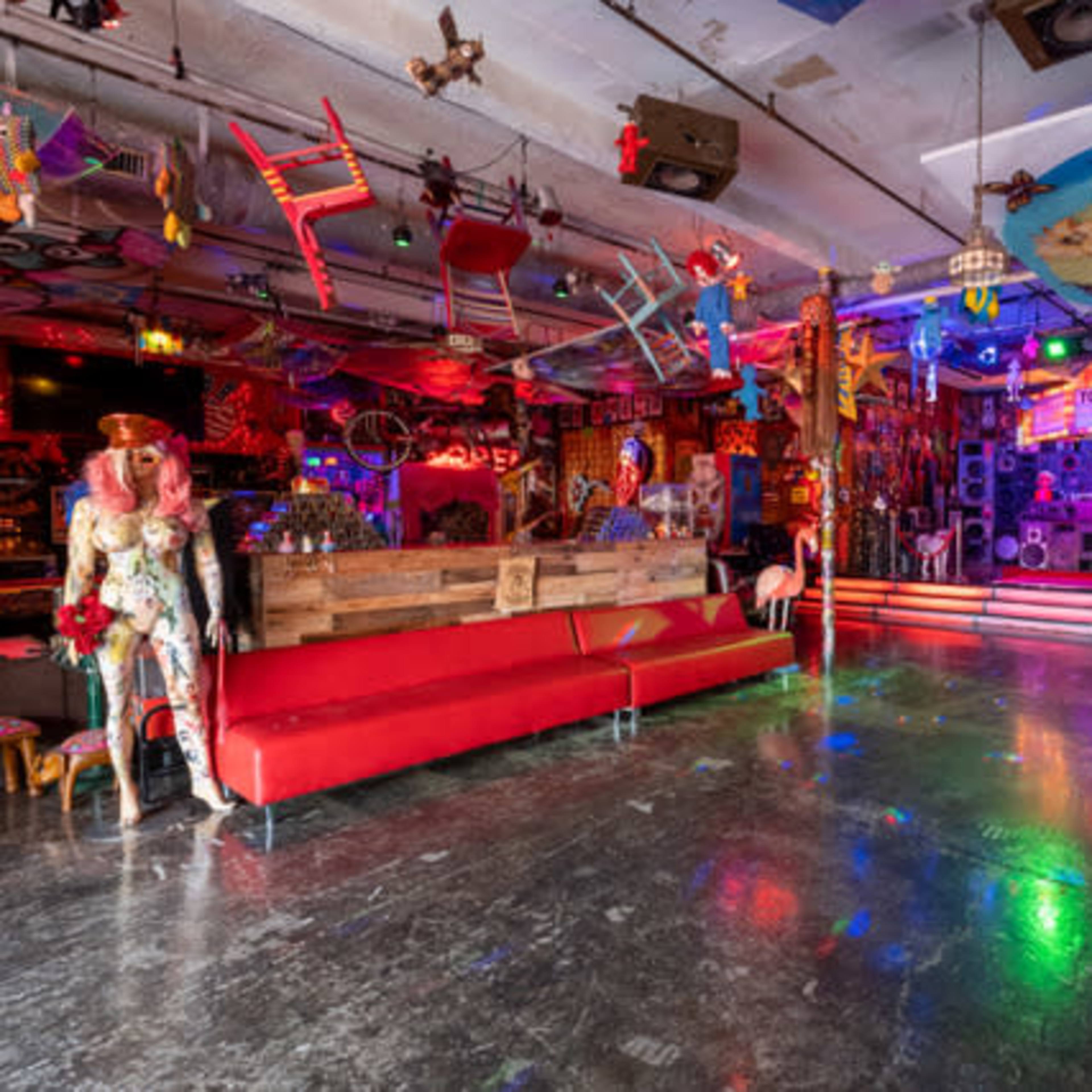 A vibrant, eclectic interior of a creatively decorated room filled with colorful furniture, art, and various playful elements.