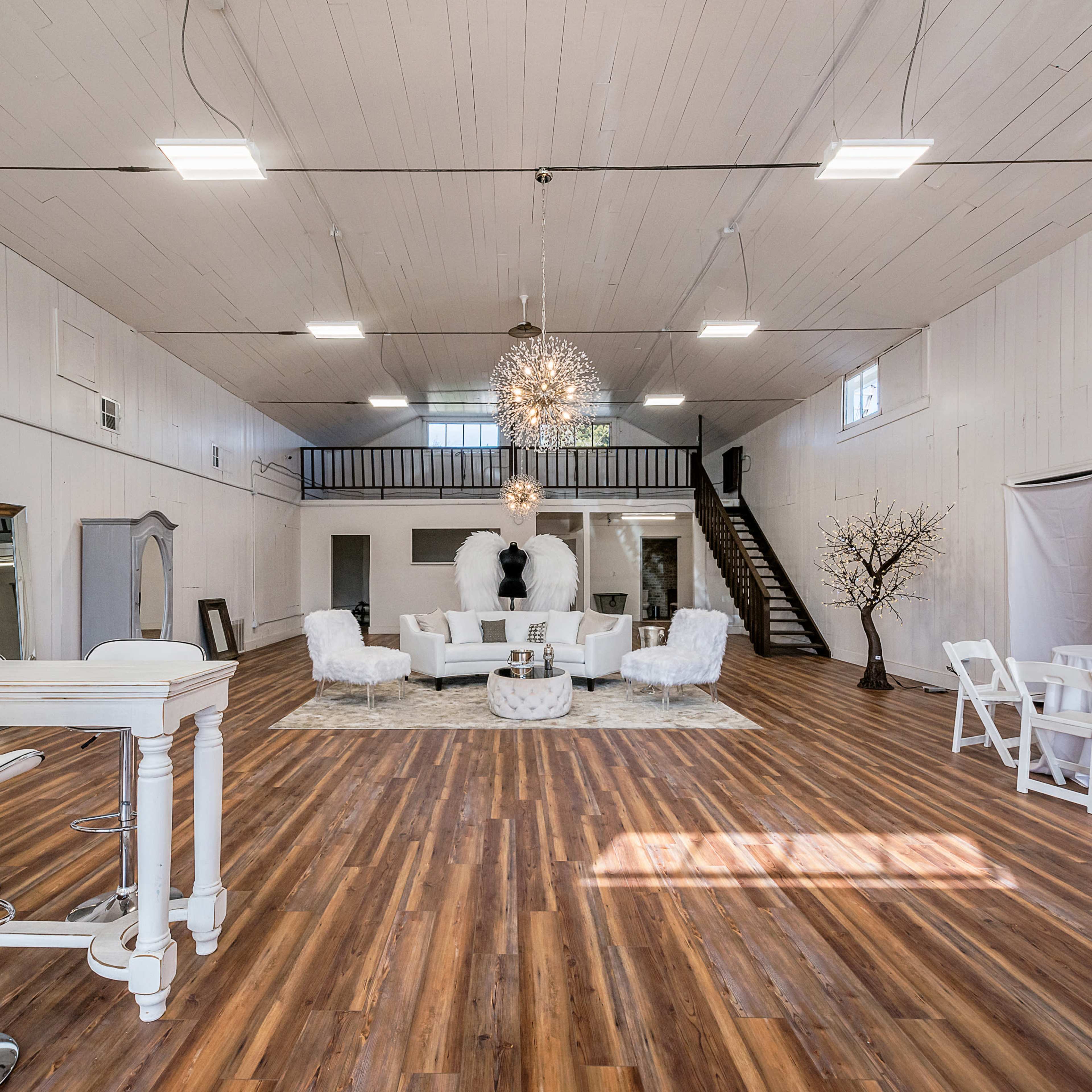 A spacious, well-lit interior featuring modern furniture, elegant lighting, and hardwood flooring.