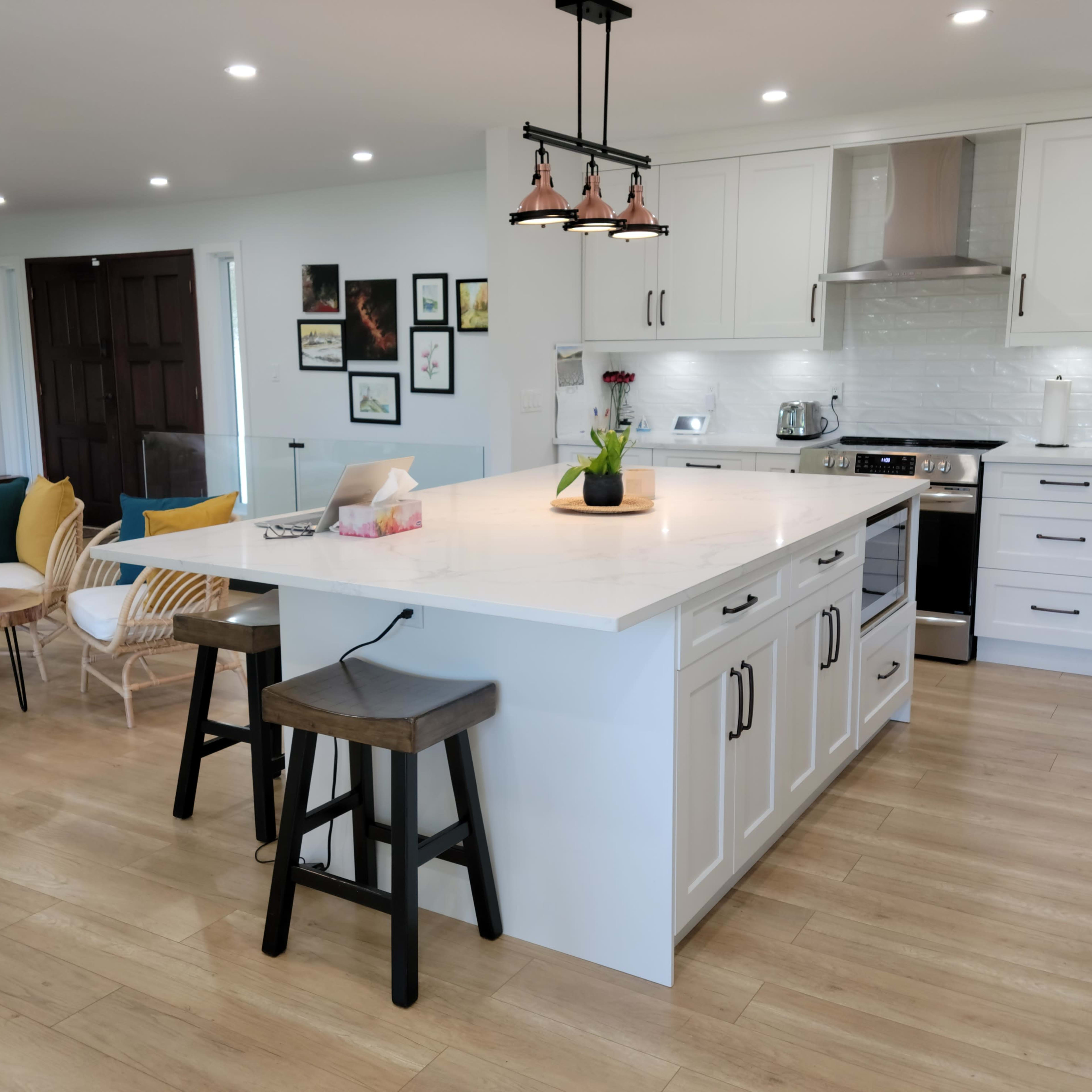 A modern kitchen with a large island, surrounded by various seating options and casual decor.