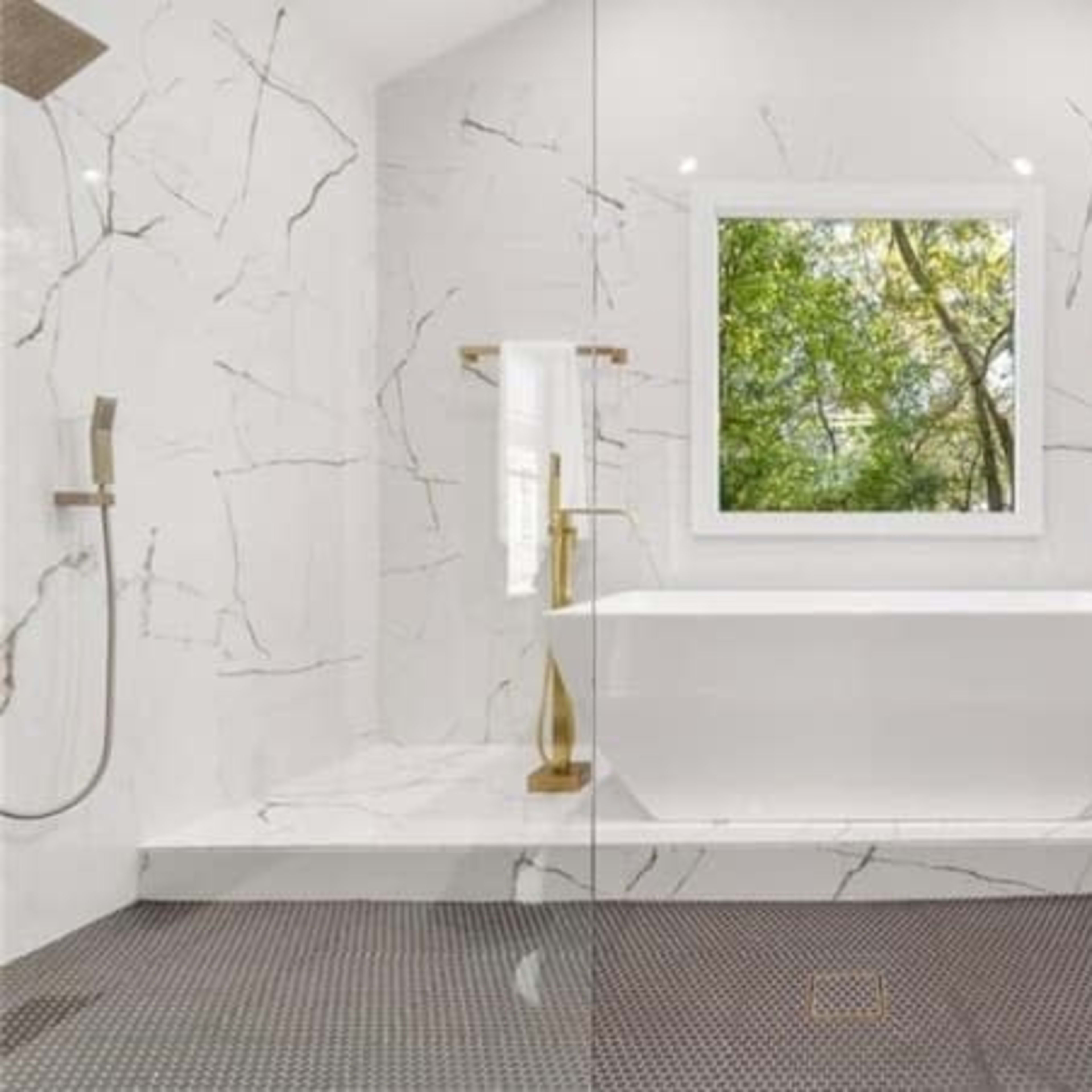 A modern bathroom featuring a freestanding bathtub, large windows with a view of greenery, and marble walls with gold fixtures.