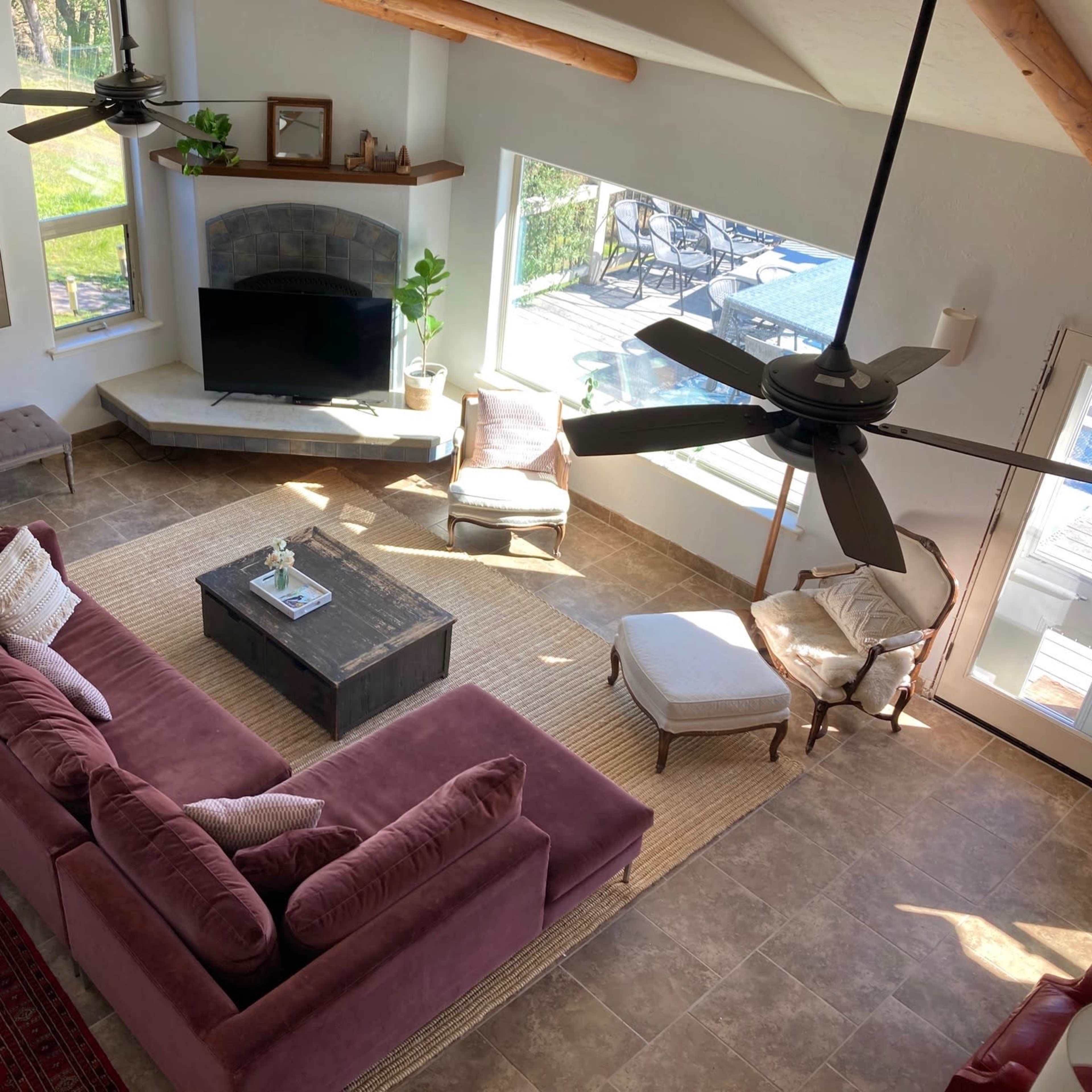 A spacious living room with a large sectional sofa, a coffee table, and a view of the outdoors through large windows.