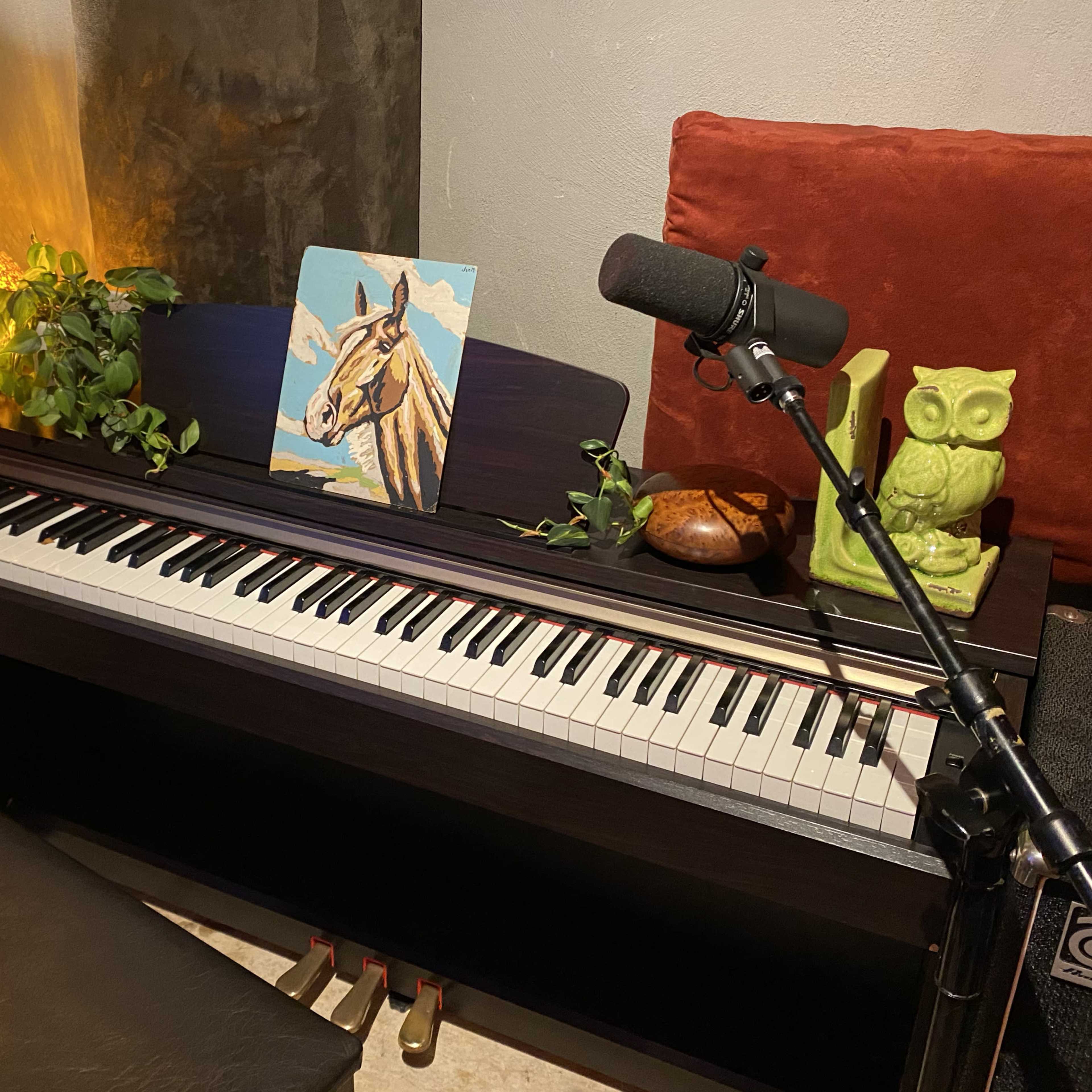 A music studio is filled with various instruments, including guitars, a drum set, and a keyboard, surrounded by soundproofing panels and ambient lighting.