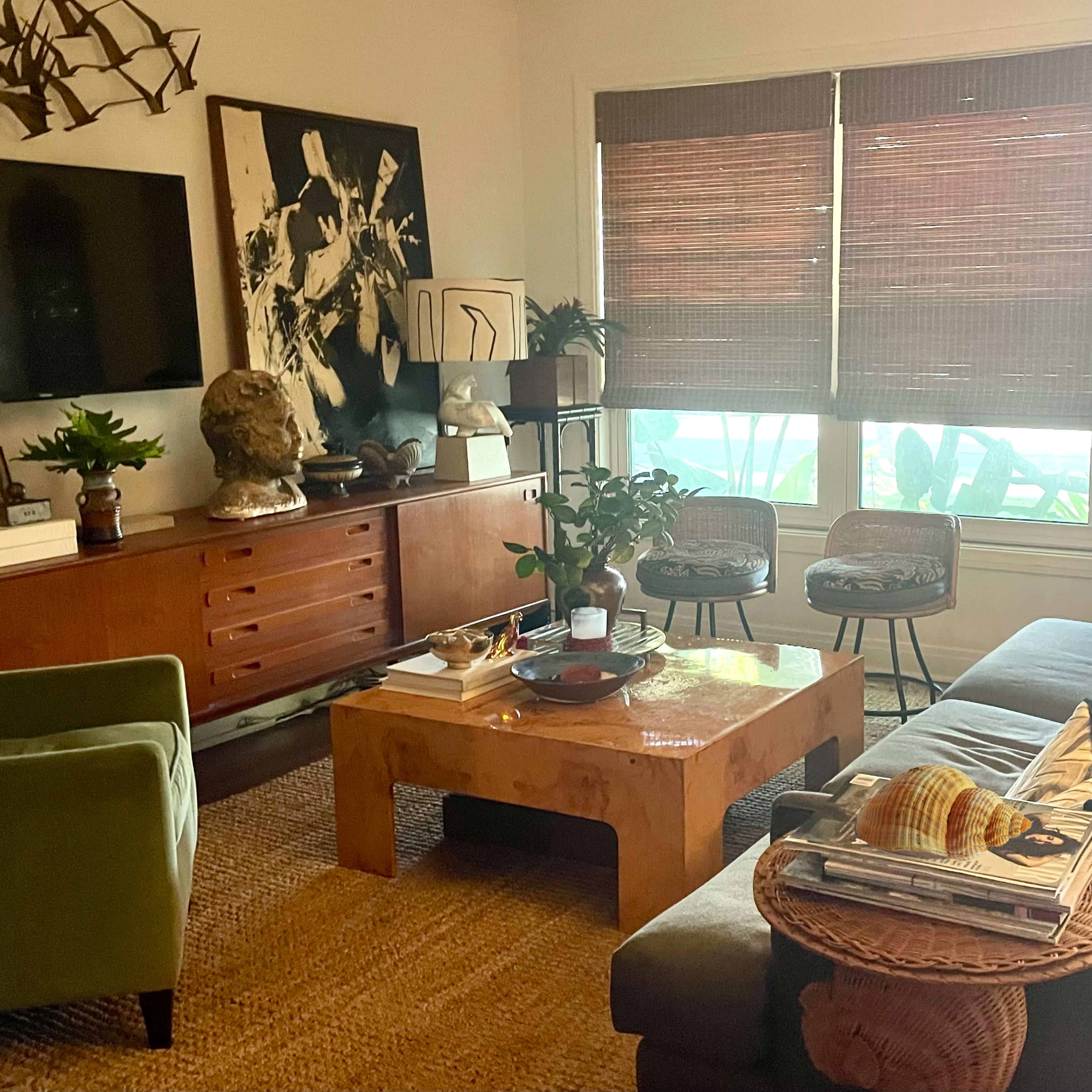 A cozy living room with a large sectional sofa, a wooden coffee table, and various decorative items on the shelves and walls.