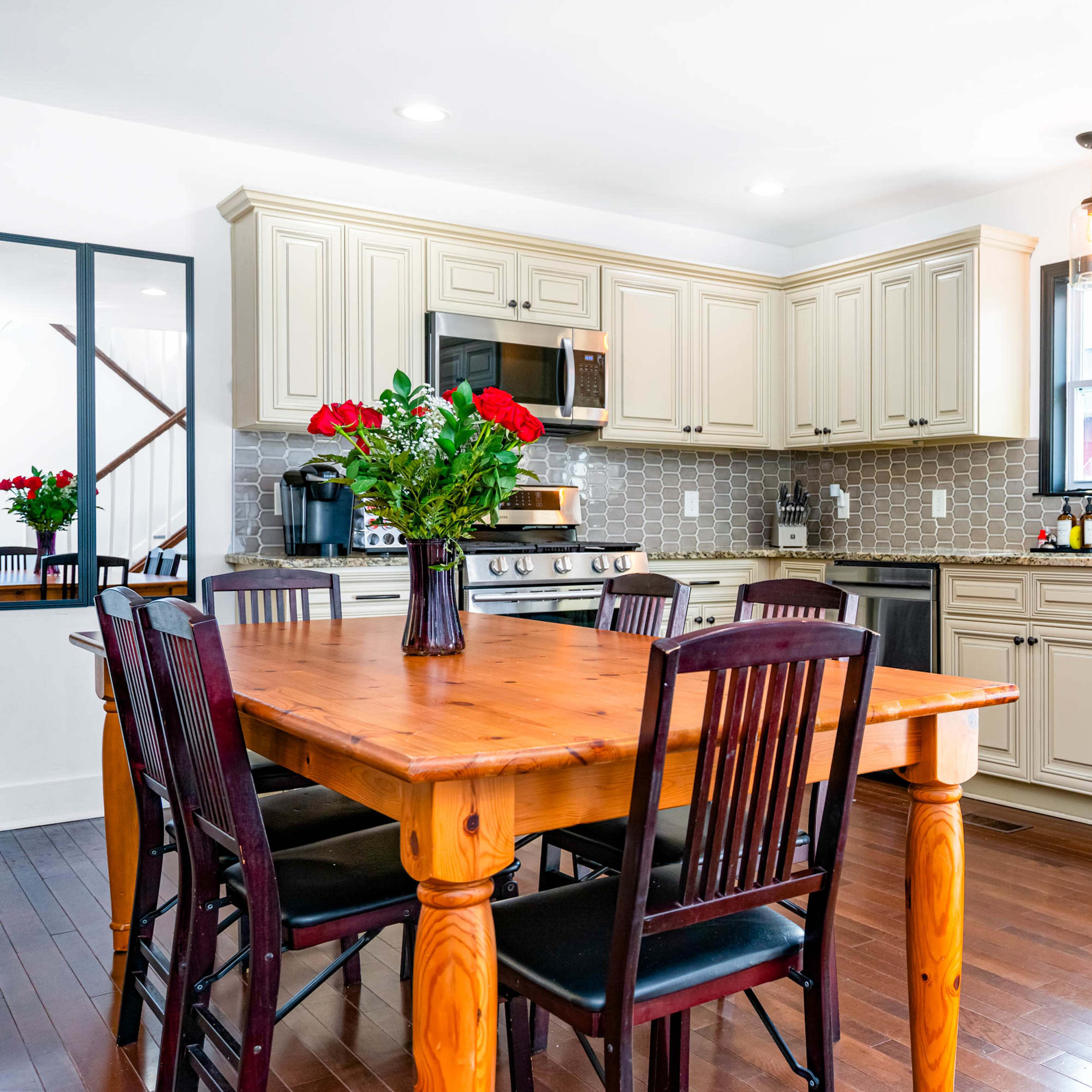 A modern kitchen features wooden furniture, stainless steel appliances, and light-colored cabinetry.