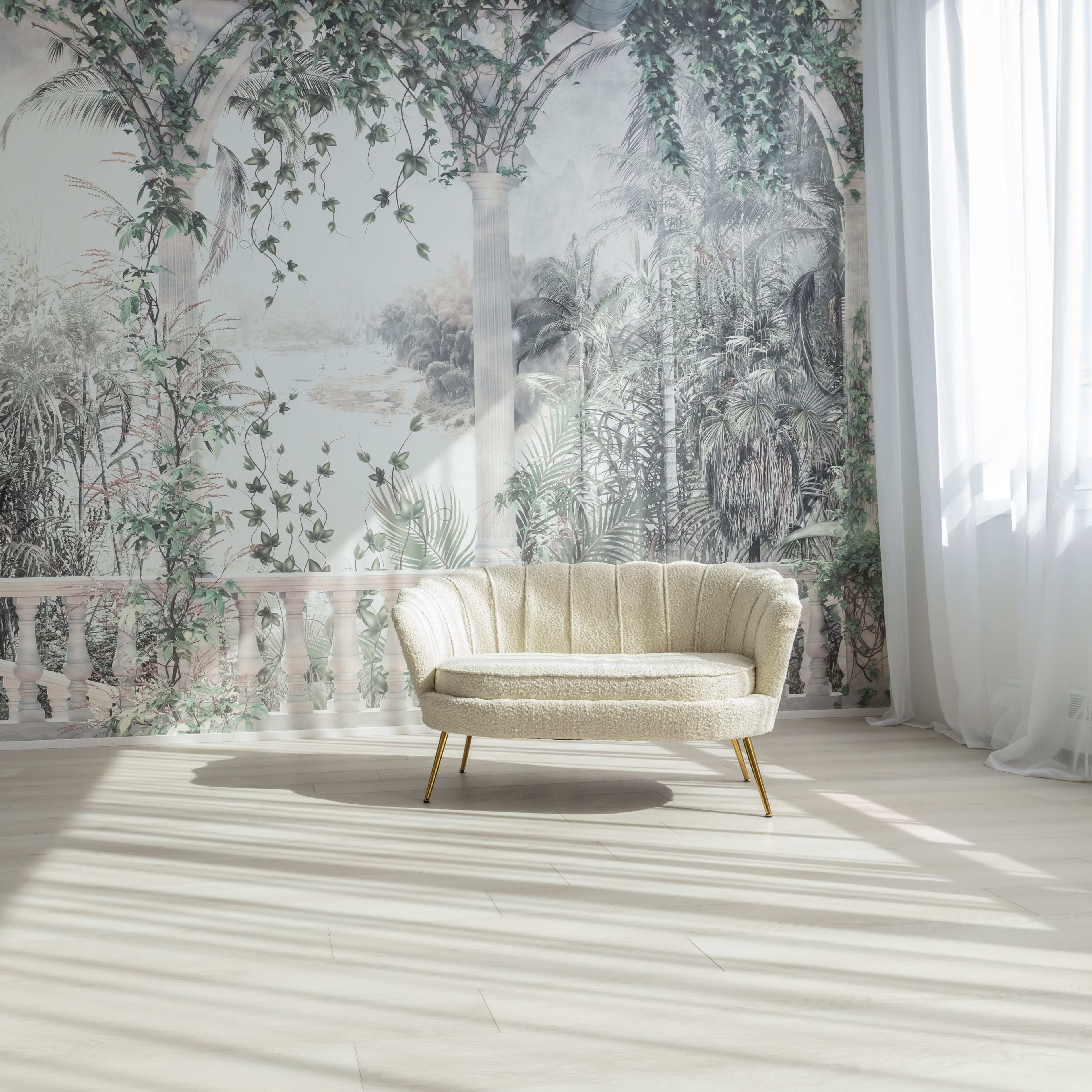 A cozy circular sofa positioned in a sunlit room with a dramatic wall mural featuring tropical plants and an arched architectural design.