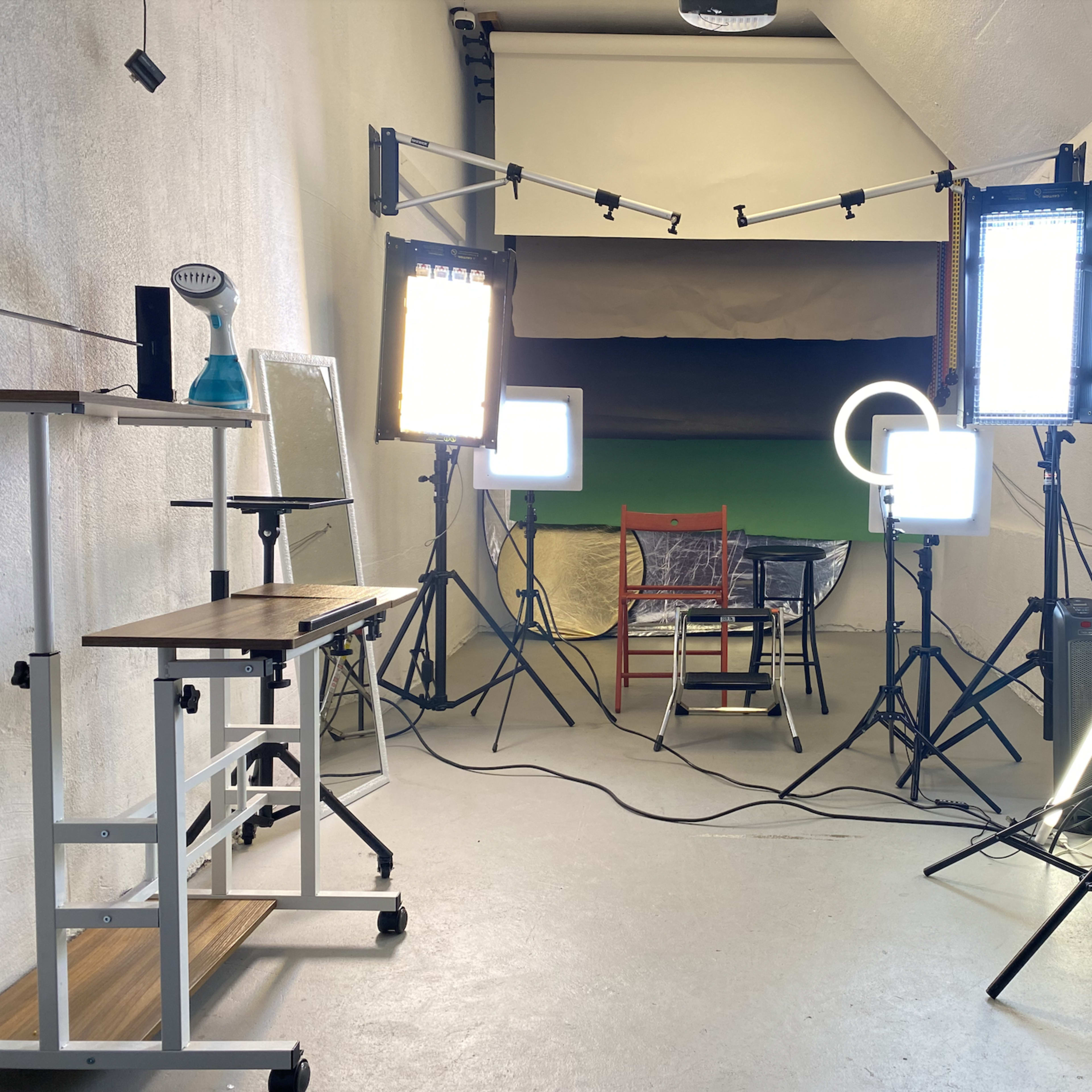 A photography studio is set up with multiple lights illuminating a central chair against a backdrop.