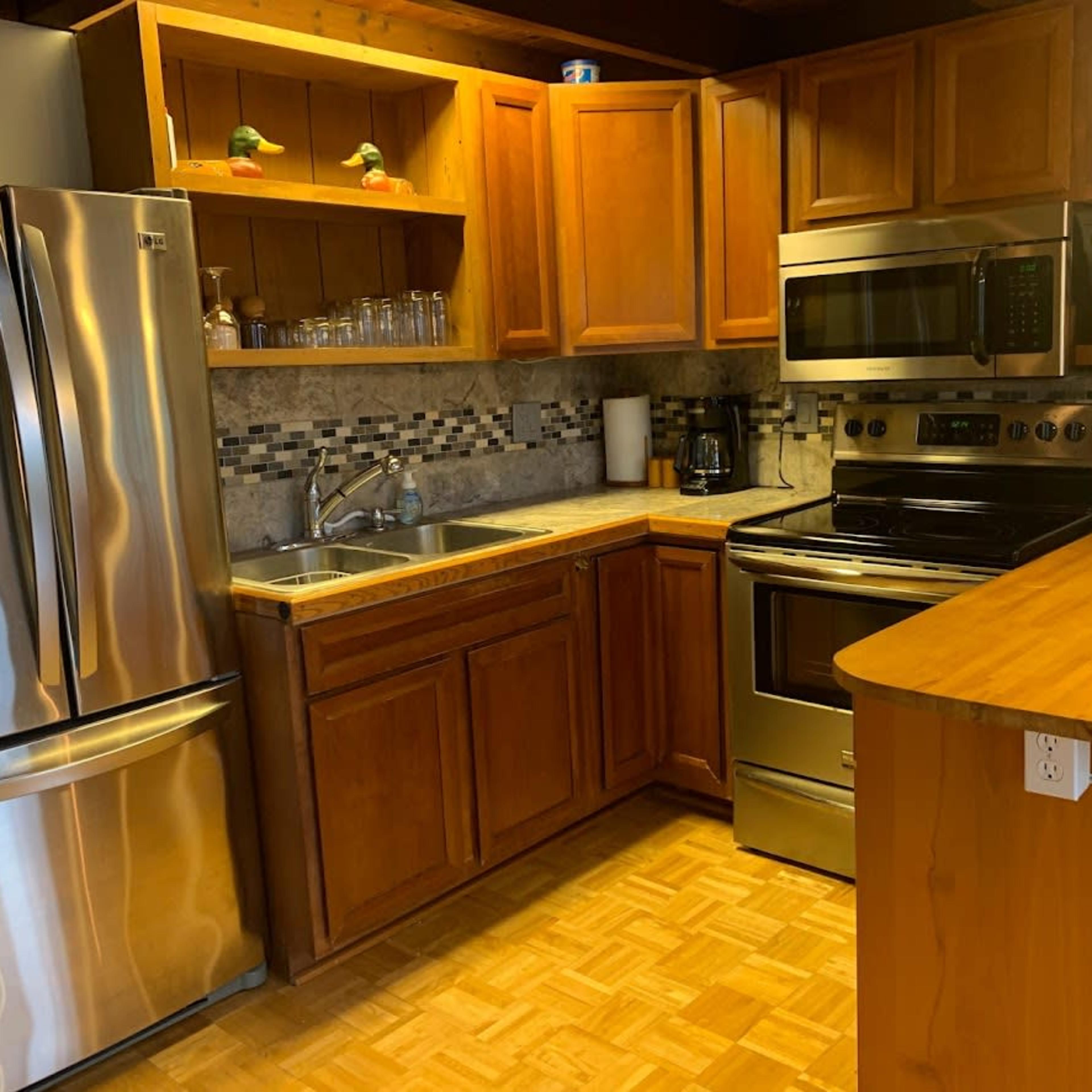 A kitchen featuring wooden cabinets, stainless steel appliances, a sink, and a countertop.