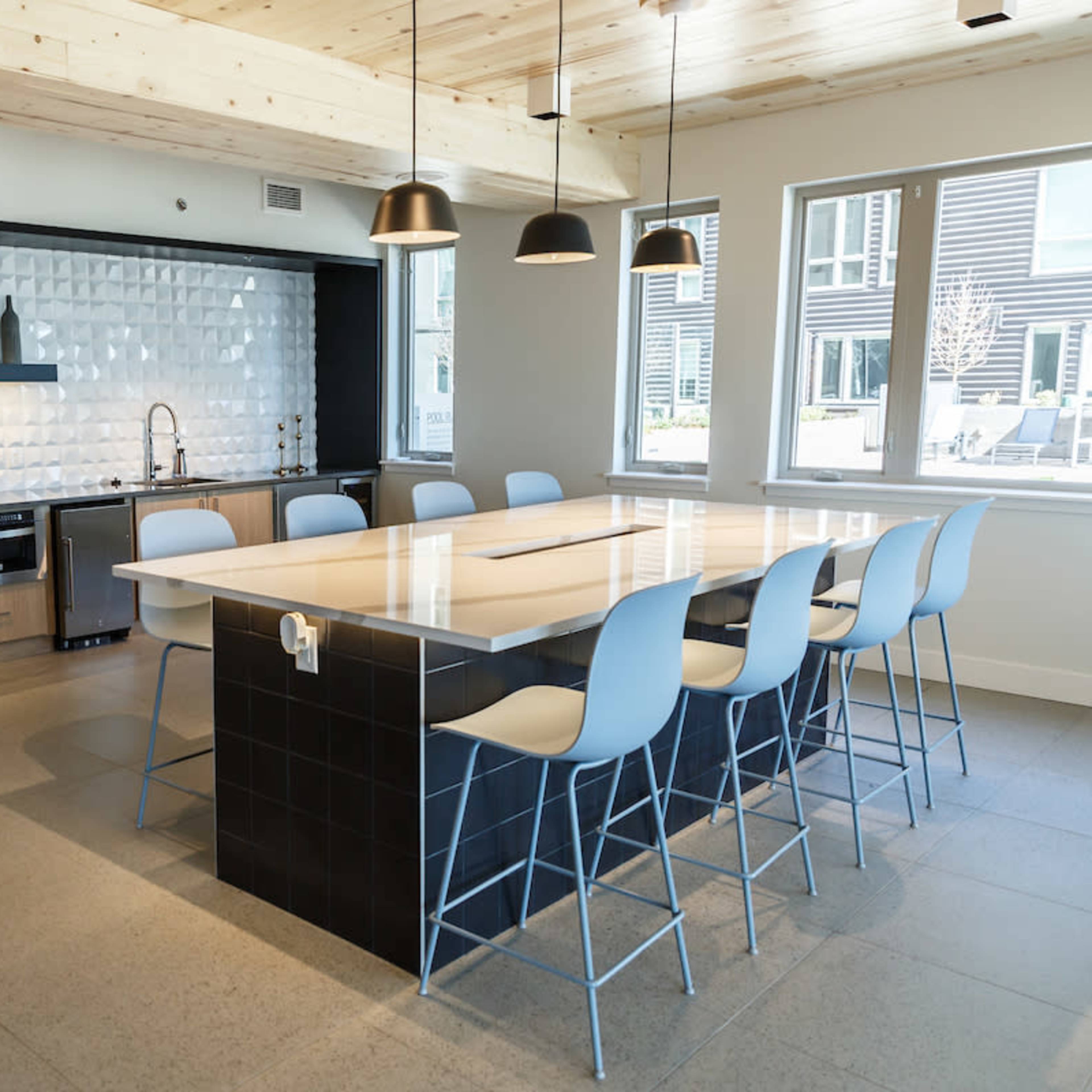 A modern kitchen with a large island, sleek cabinetry, and a white tiled backsplash.