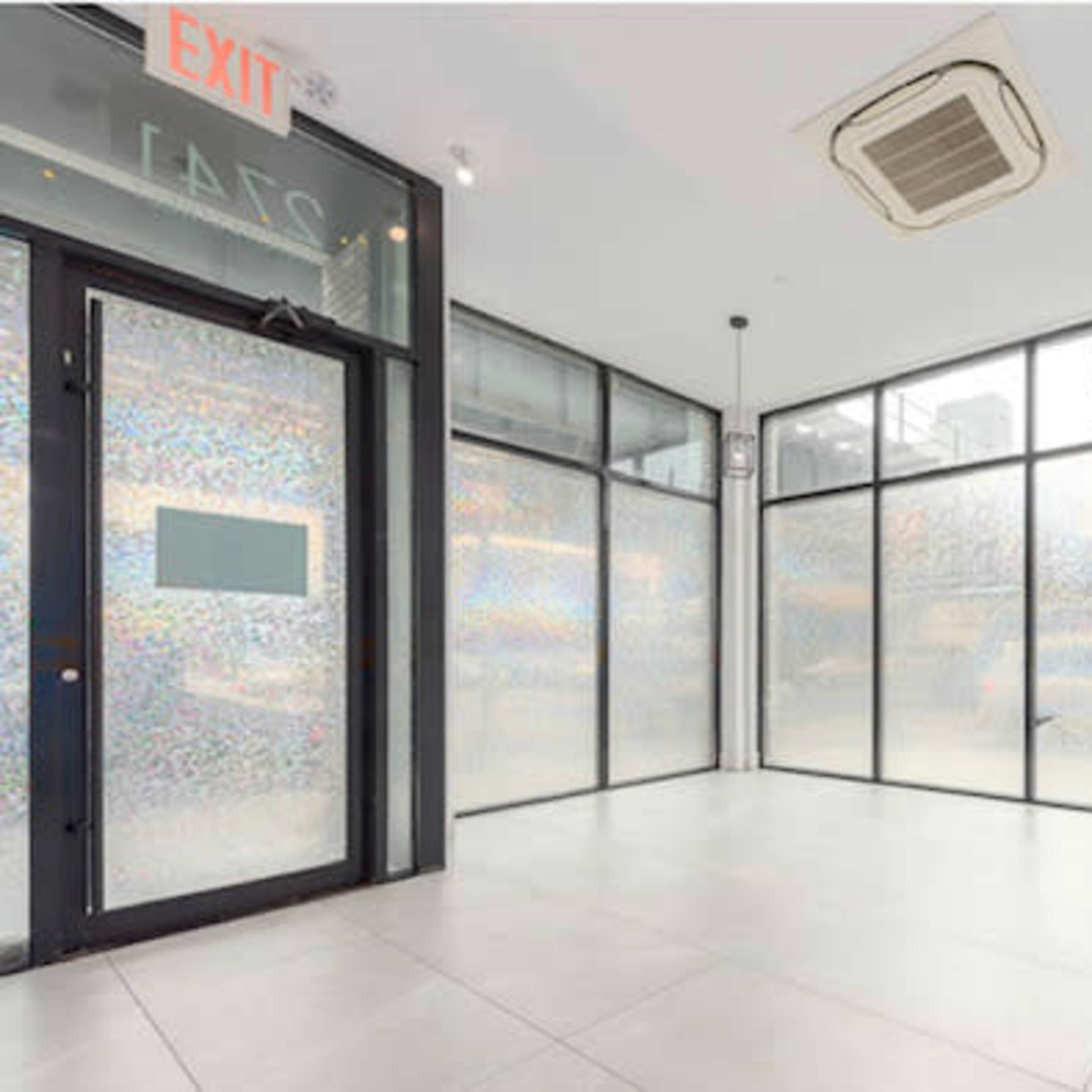 An empty retail space with large windows and a modern interior design.