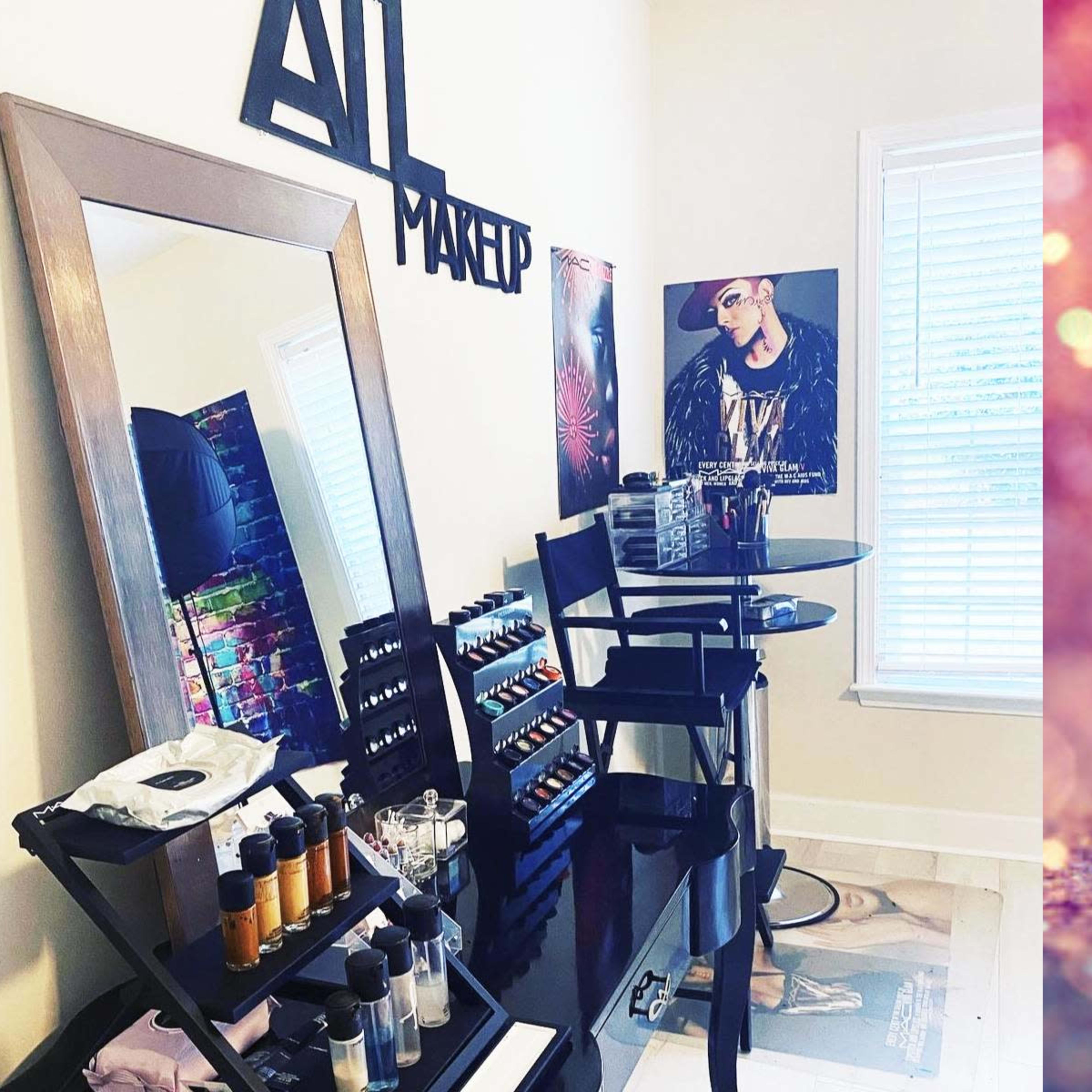 A makeup station featuring a large mirror, a display of various makeup products, and a small table in a well-lit room.