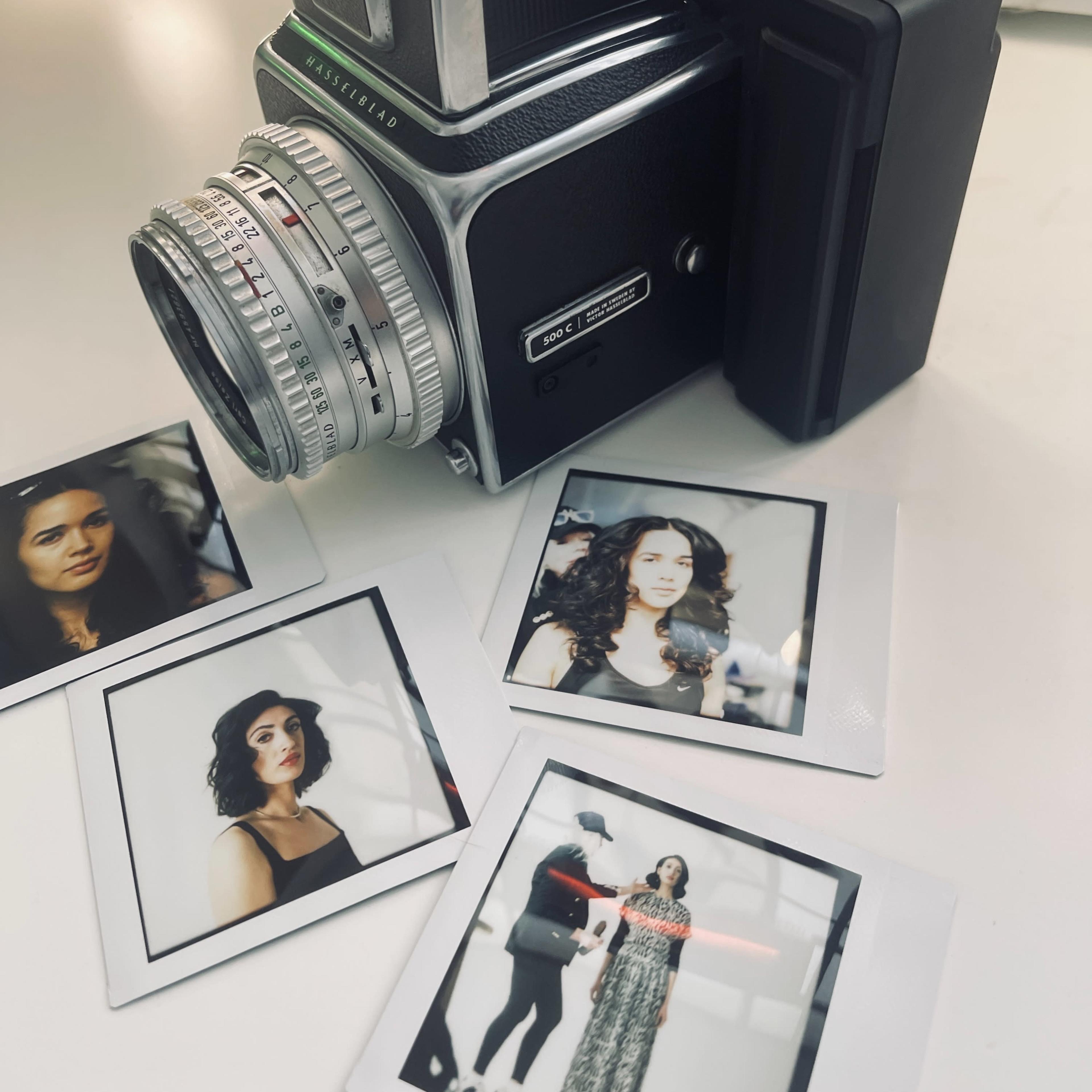 A vintage camera is positioned next to several printed photographs featuring a model in various poses.