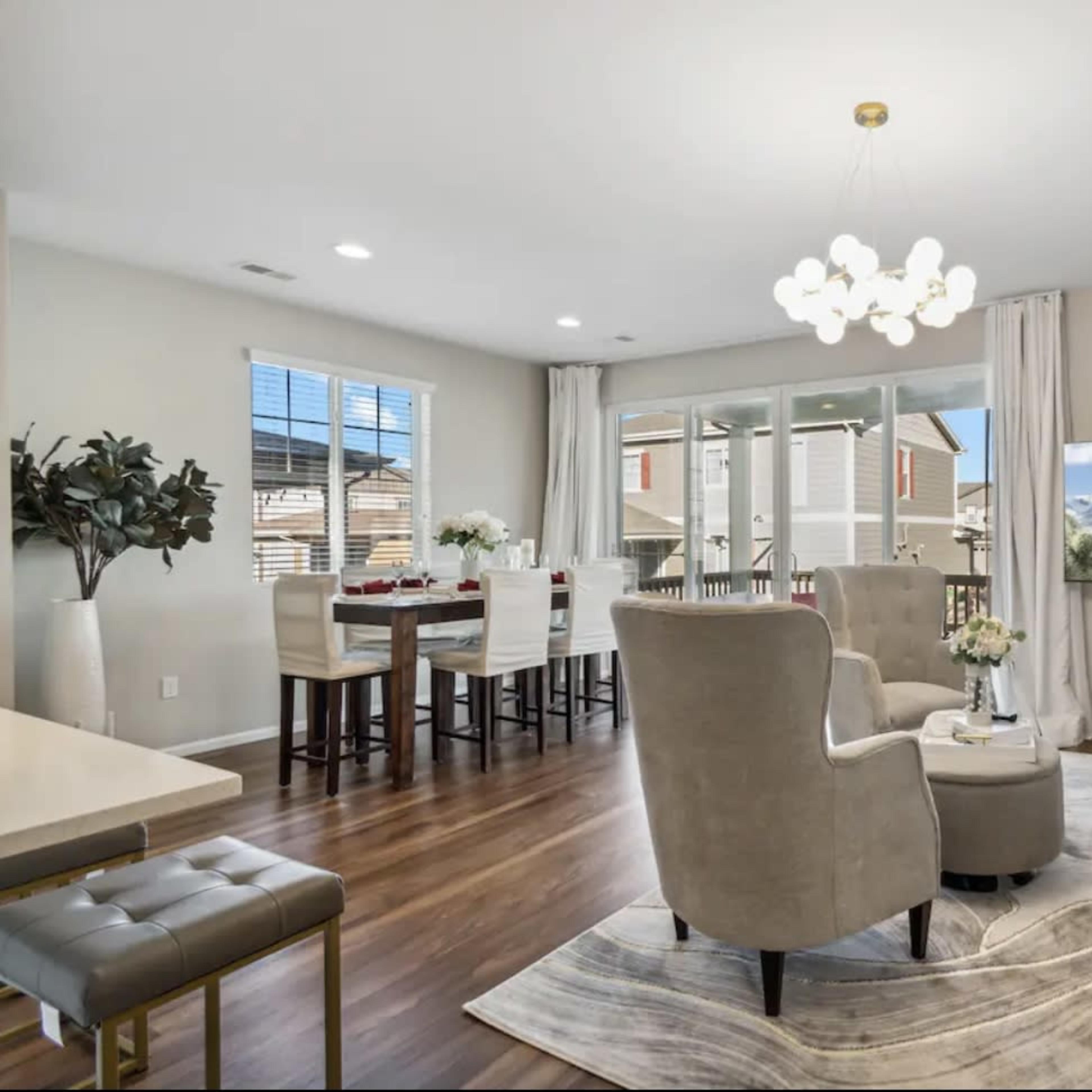 A modern living and dining area featuring seating, a coffee table, and a large television.