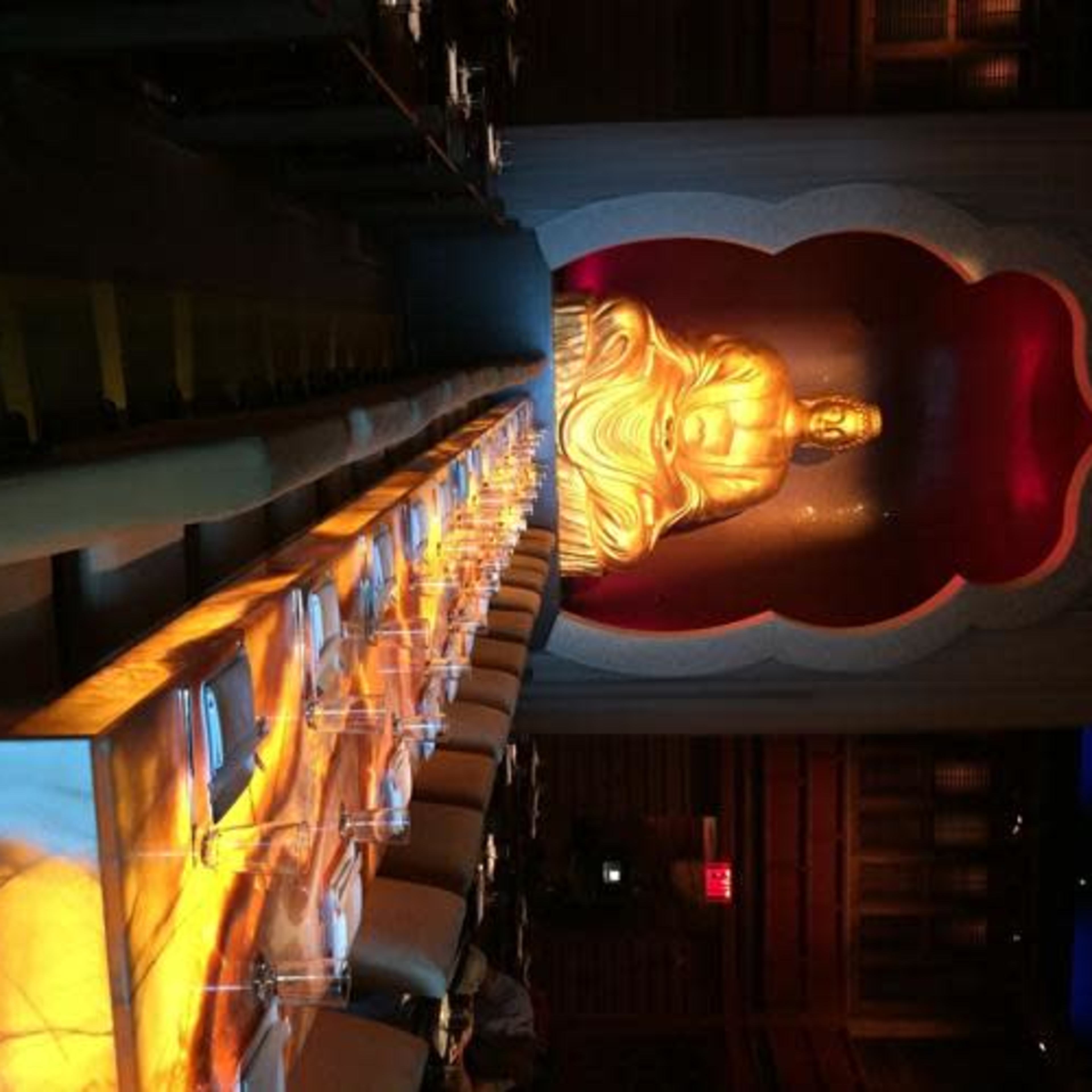 A long dining table in a restaurant with a large golden Buddha statue set against a red and gold backdrop.