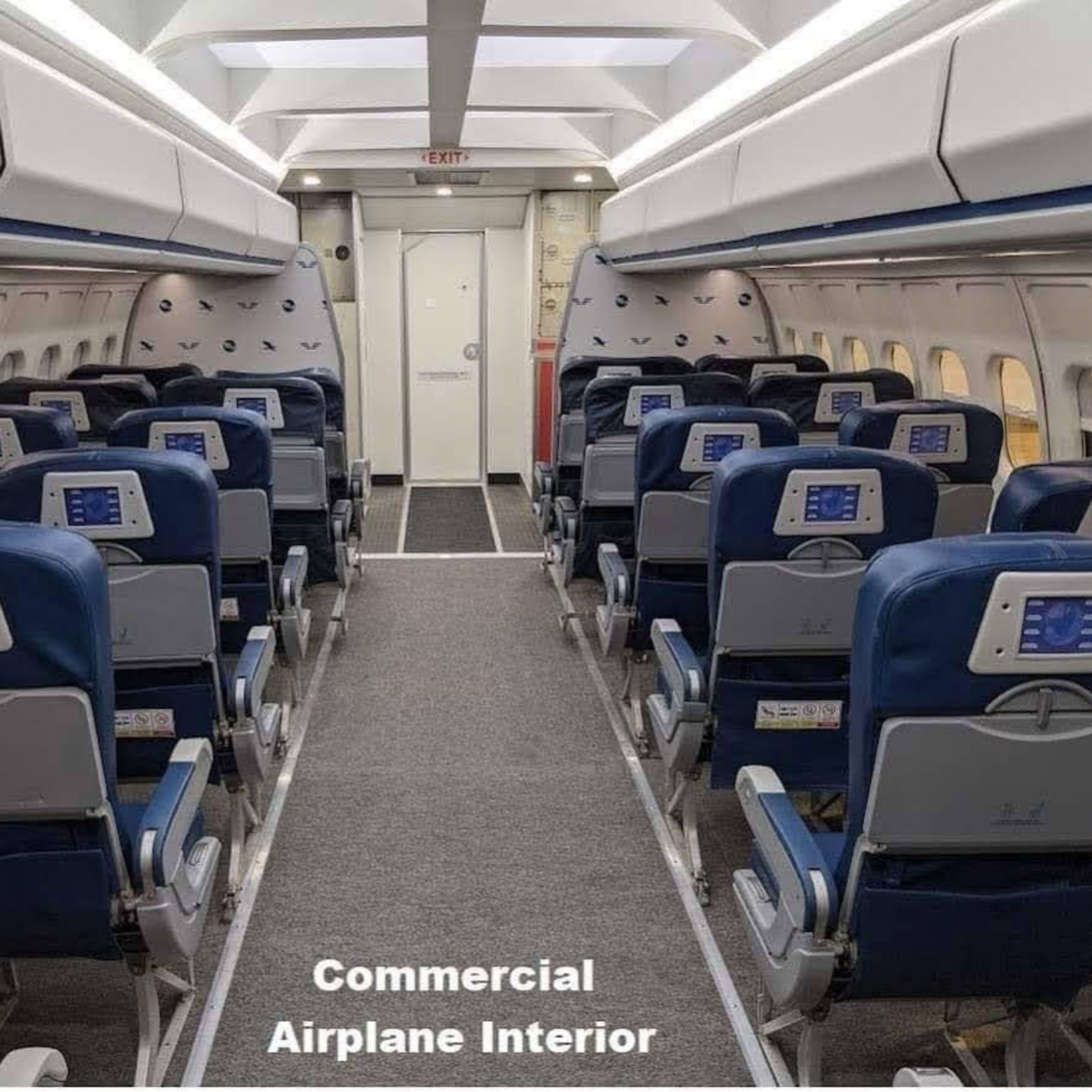 The interior of a commercial airplane with rows of seats and an aisle leading to the exit.