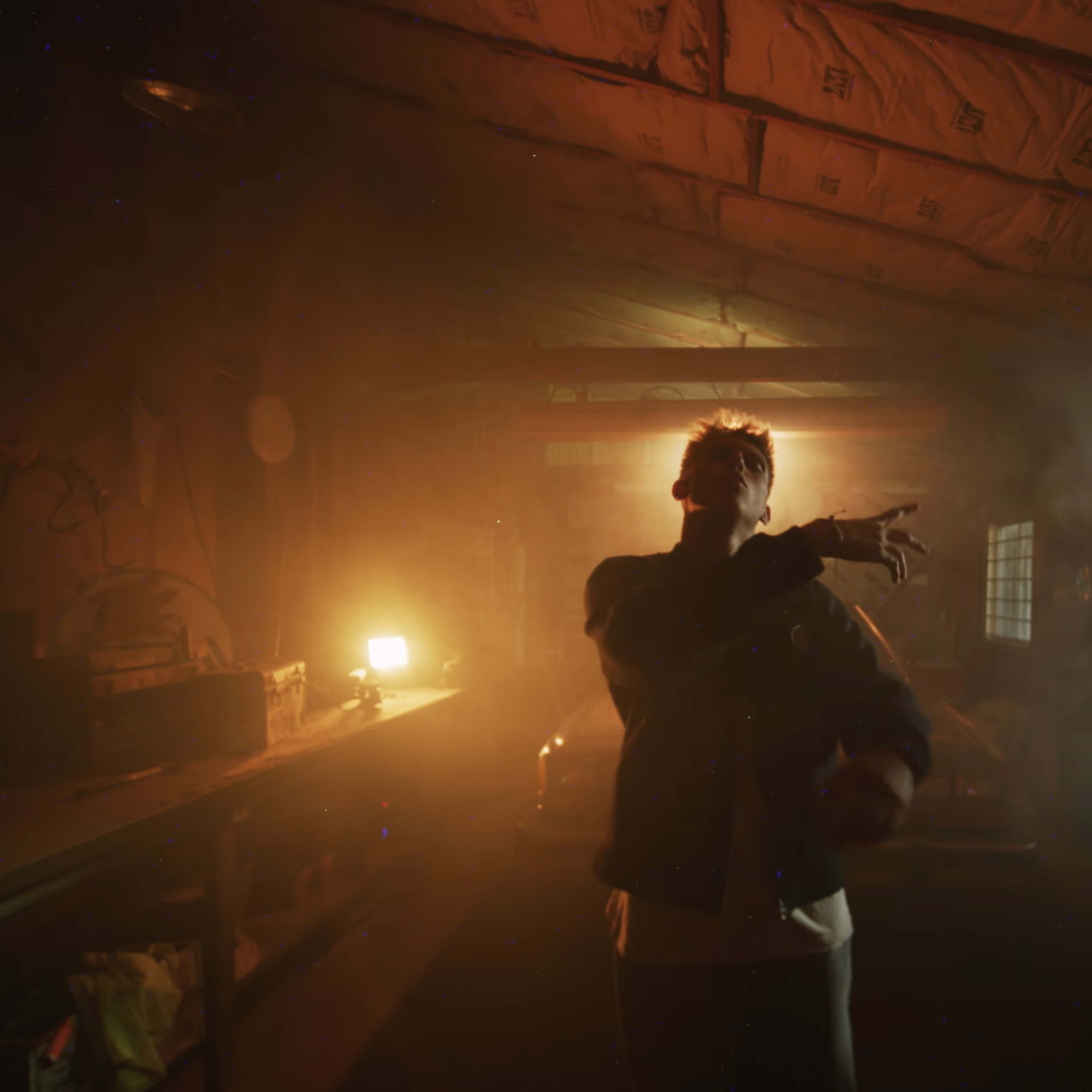 A person stands in a dimly lit, smoky room with beams of light coming from different sources.