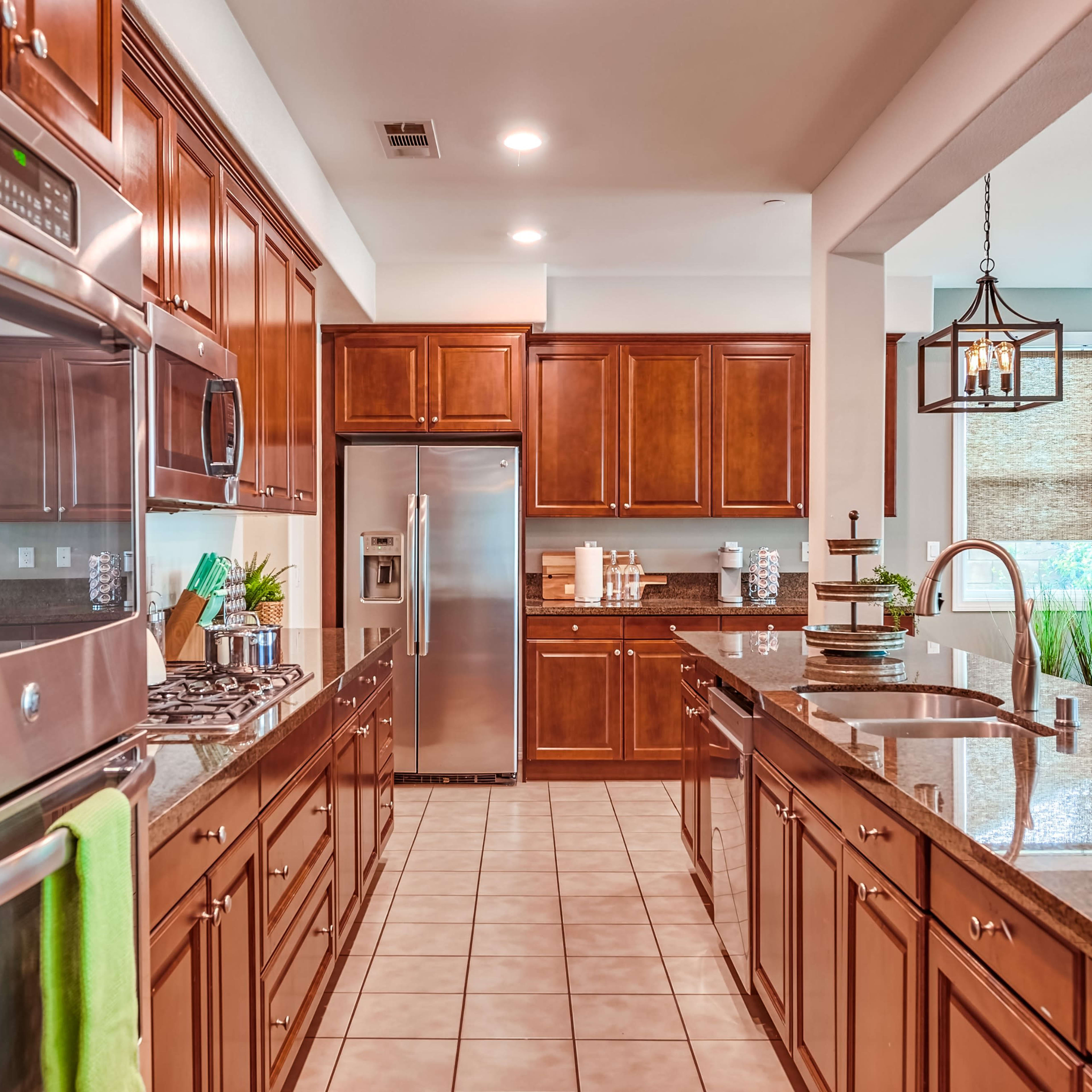 A well-organized kitchen features wooden cabinets, stainless steel appliances, and a central island with a sink and counter space.