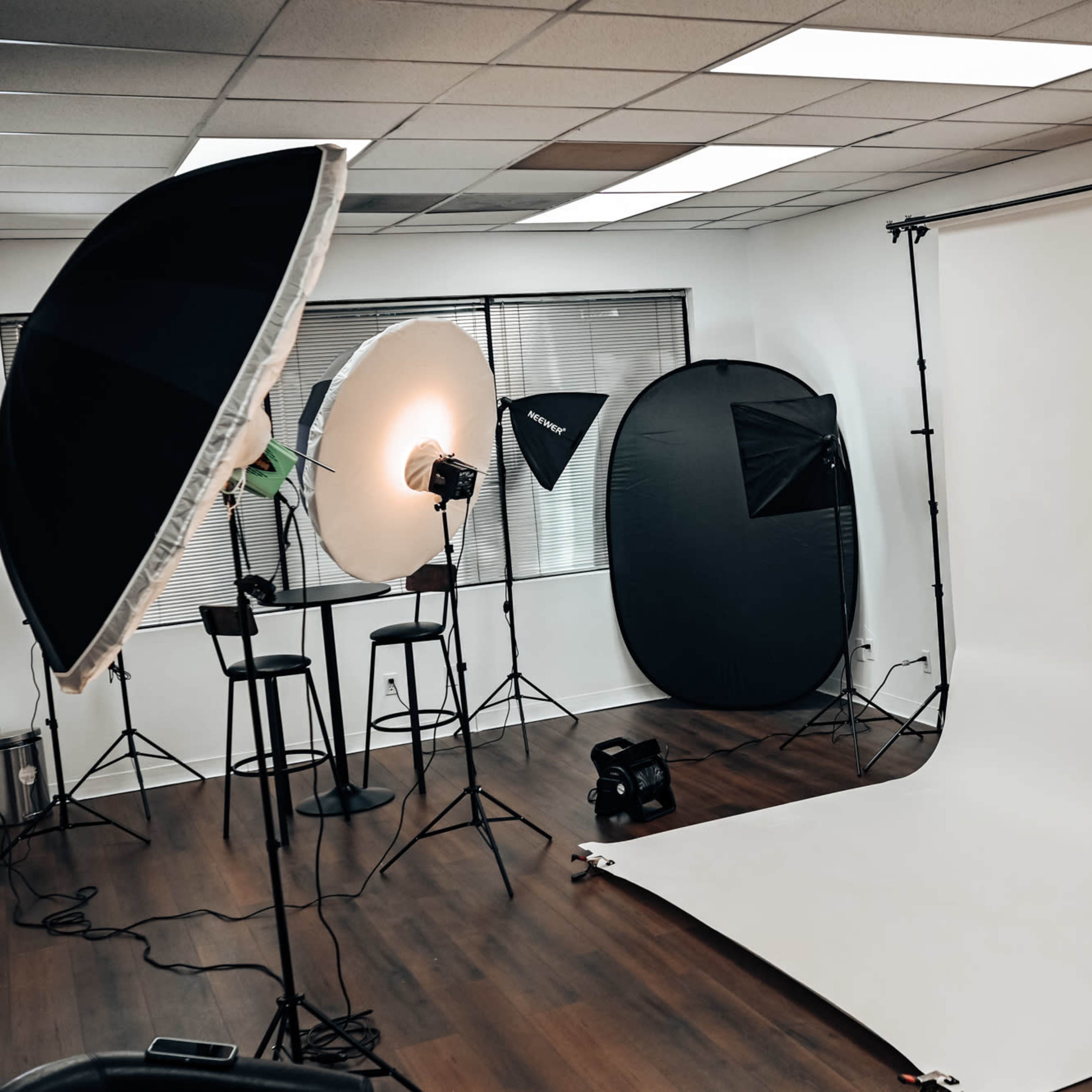 A photography studio equipped with lighting equipment, backdrops, and various props set up for a photo shoot.