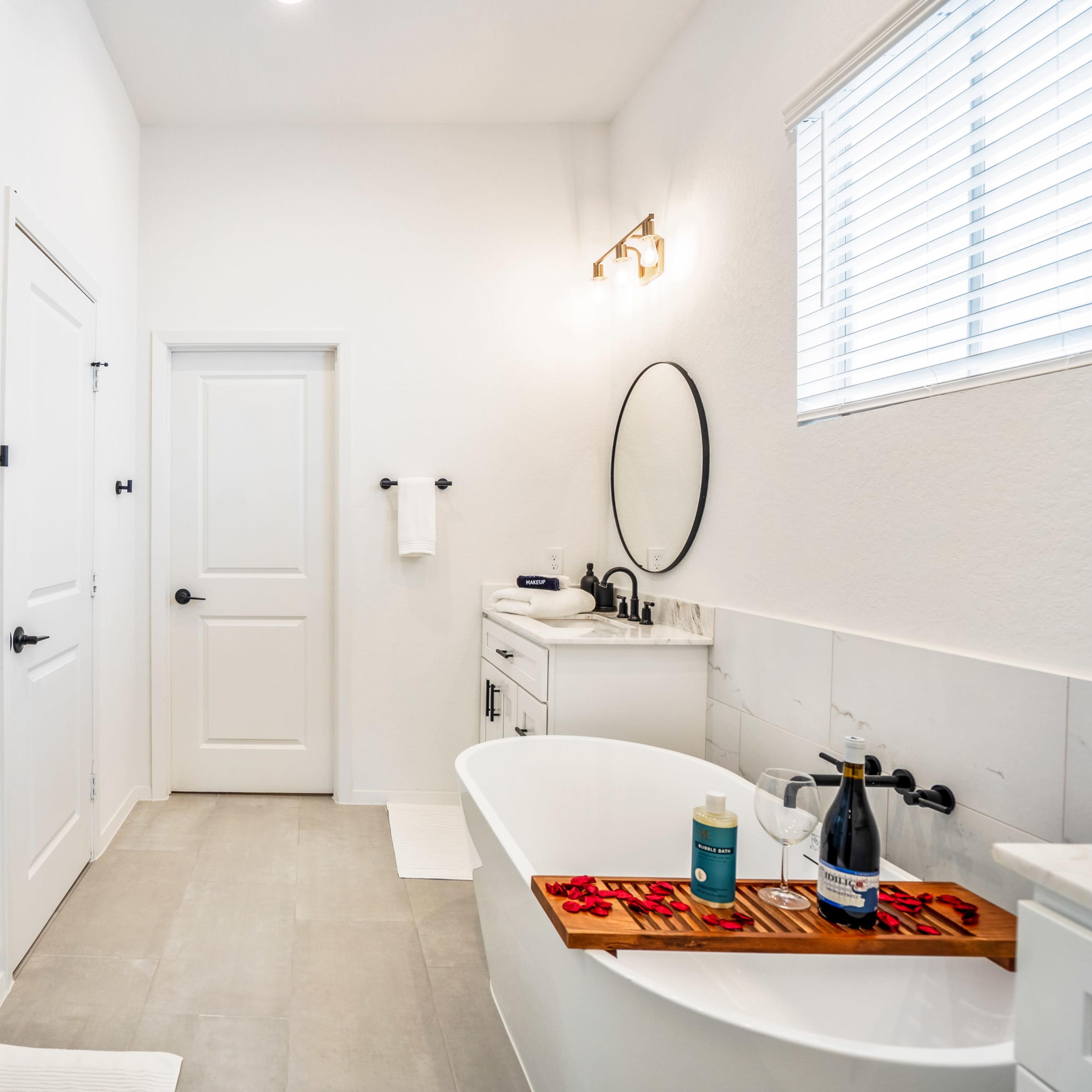 A modern bathroom featuring a freestanding bathtub, a glass shower enclosure, and a vanity with a mirror.