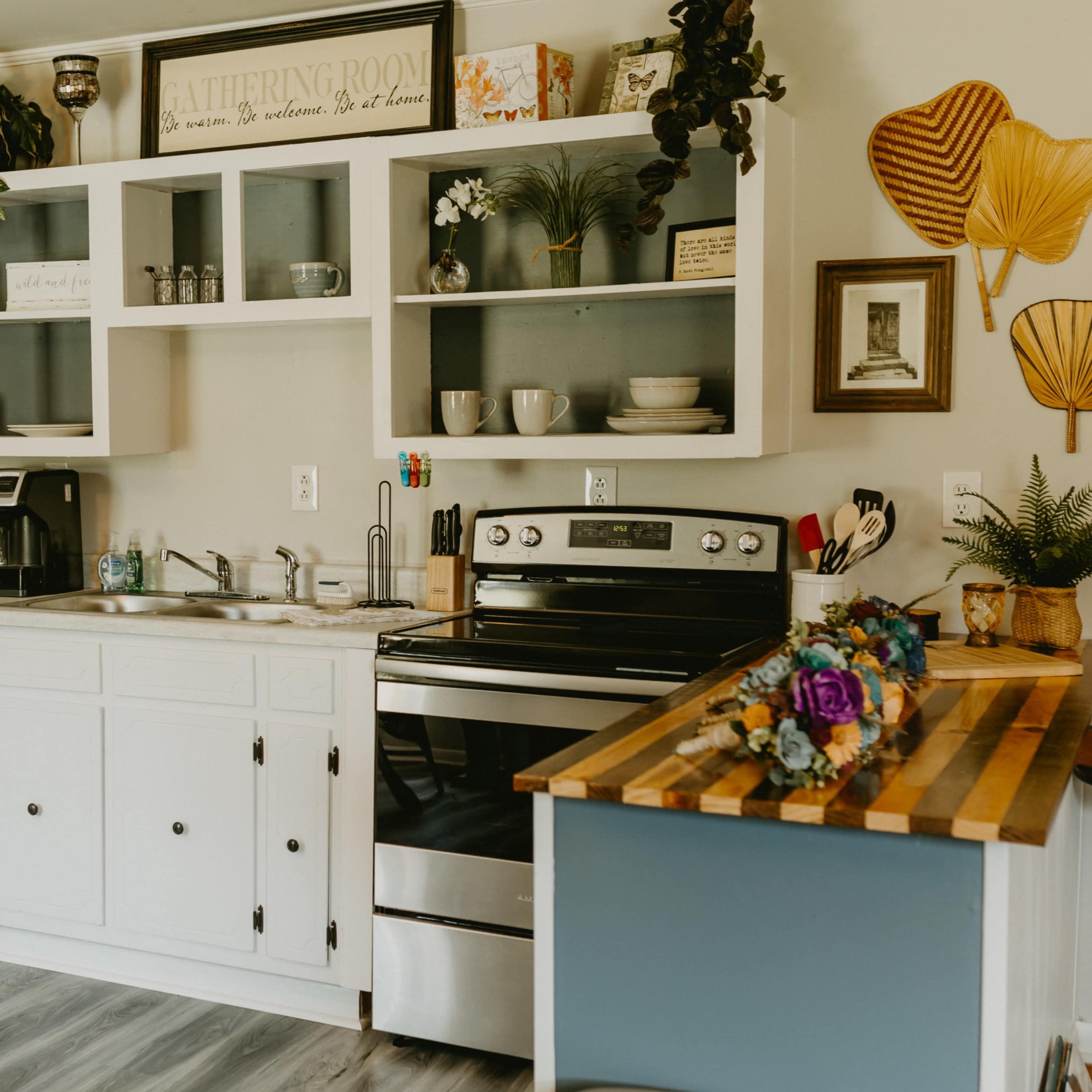 A modern kitchen features white cabinetry, a black fridge, and a wooden countertop with colorful decor.