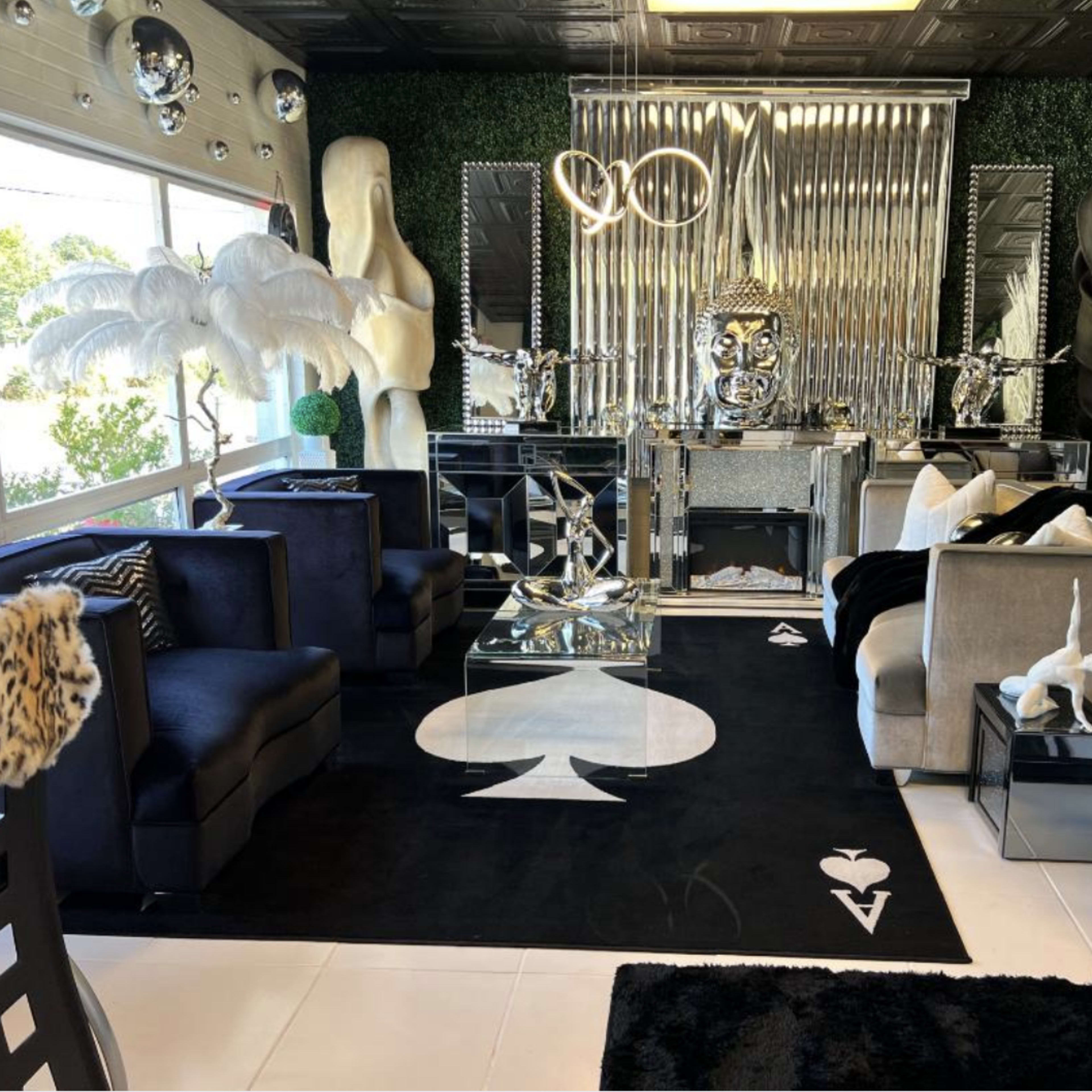 A stylish interior lounge with modern furniture, a black and white color scheme, and decorative accents including plants and sculptures.