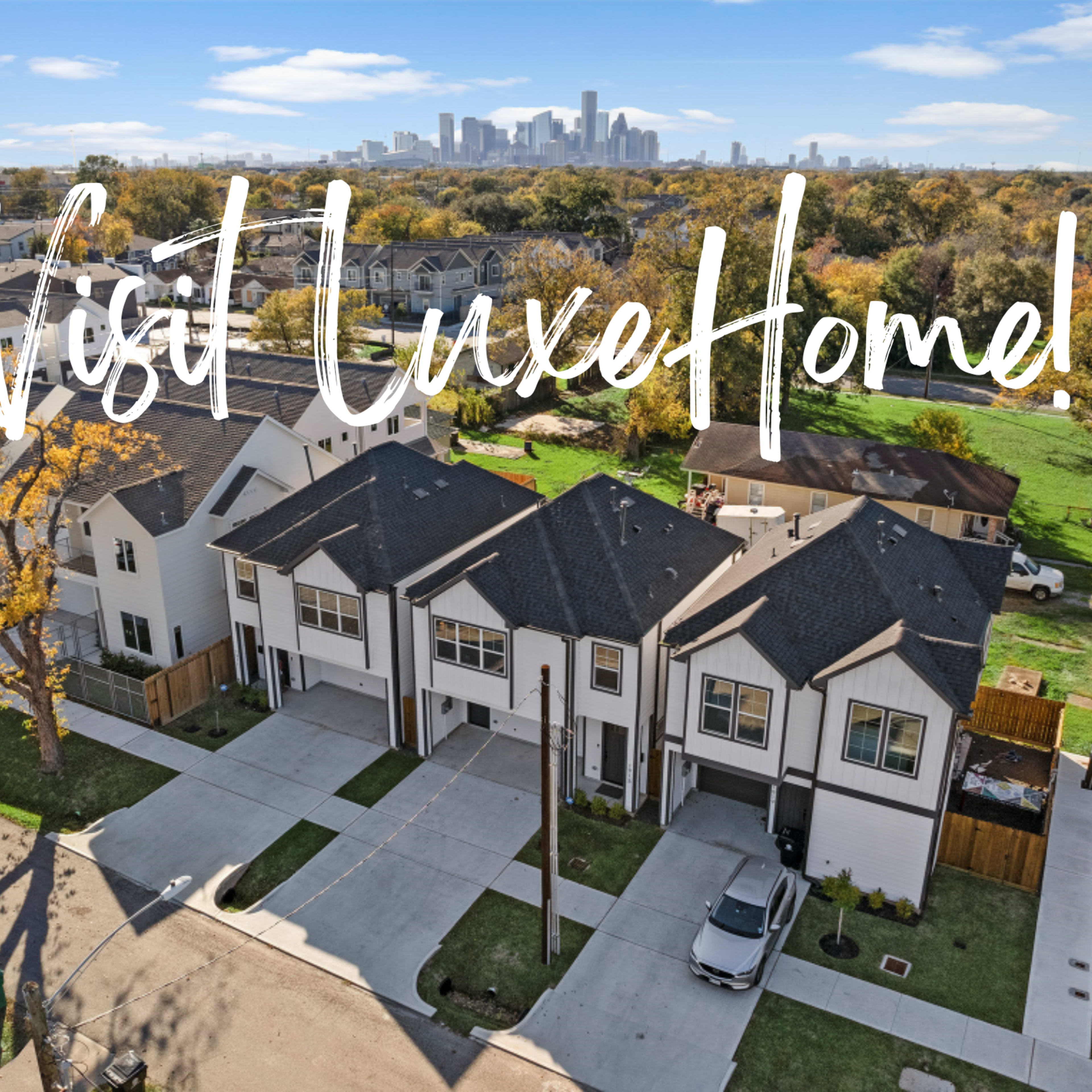 A row of modern townhouses with a clear view of a city skyline in the background.