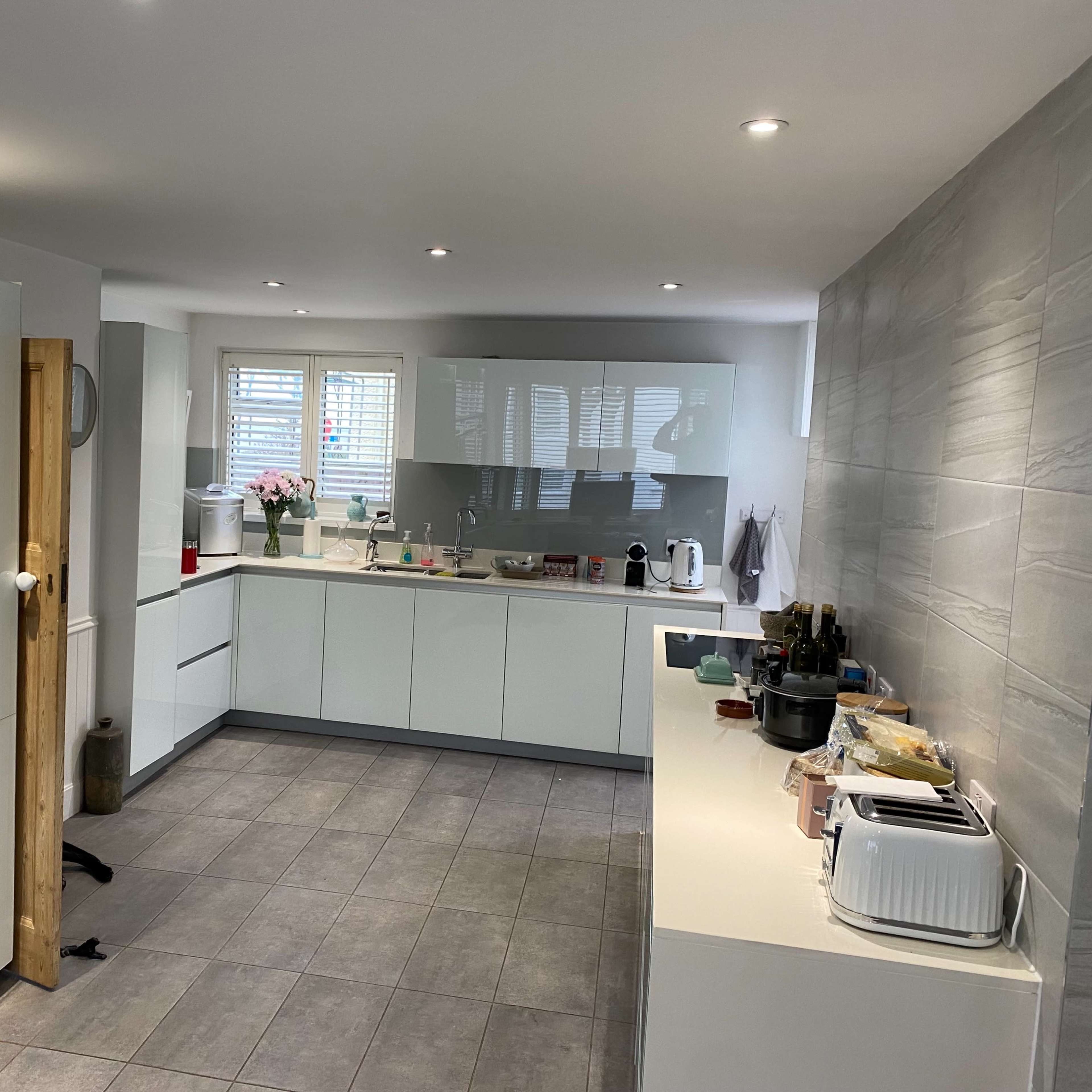 A modern kitchen featuring sleek cabinetry, stainless steel appliances, and a tiled floor.