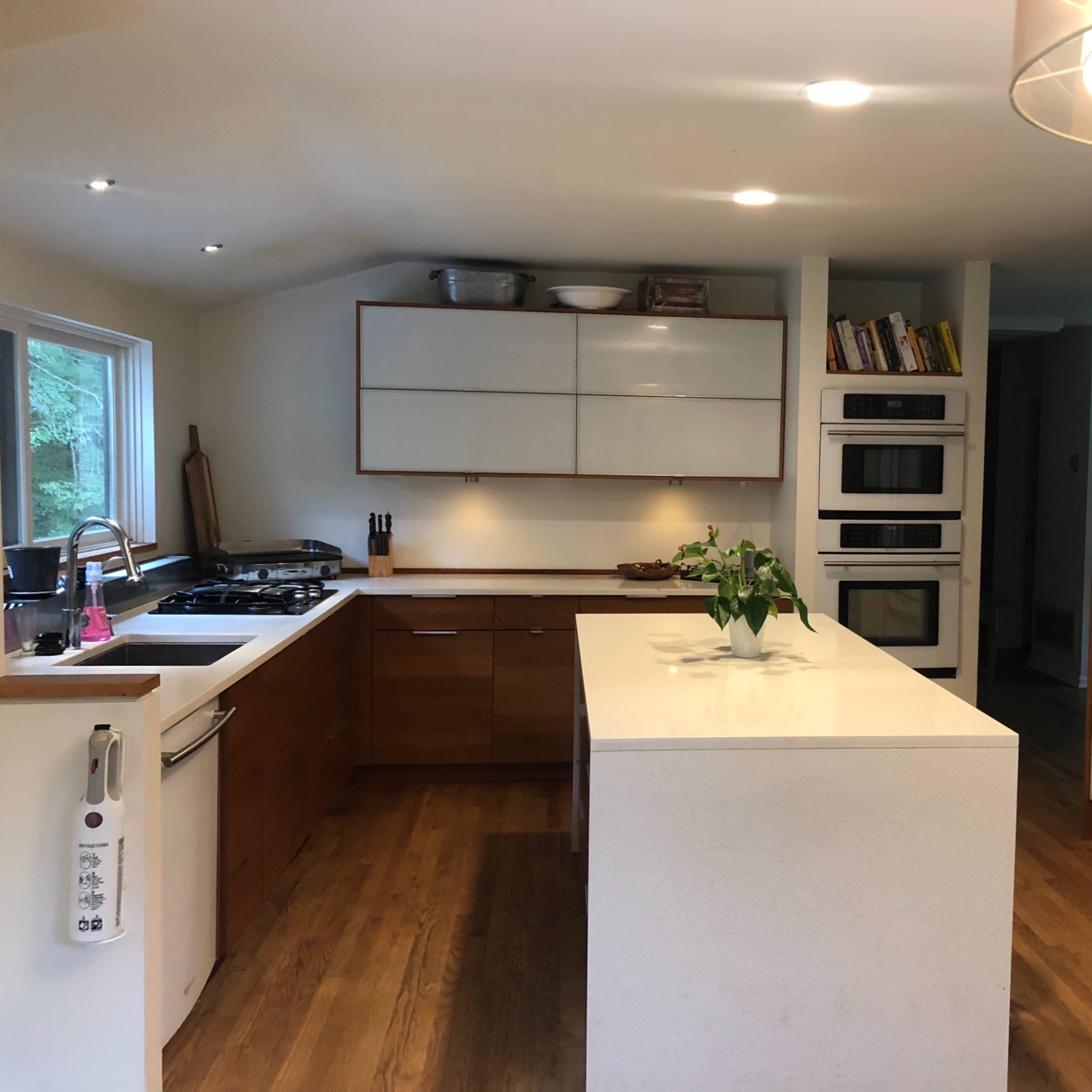 A modern kitchen featuring a central island, sleek cabinetry, and built-in appliances.