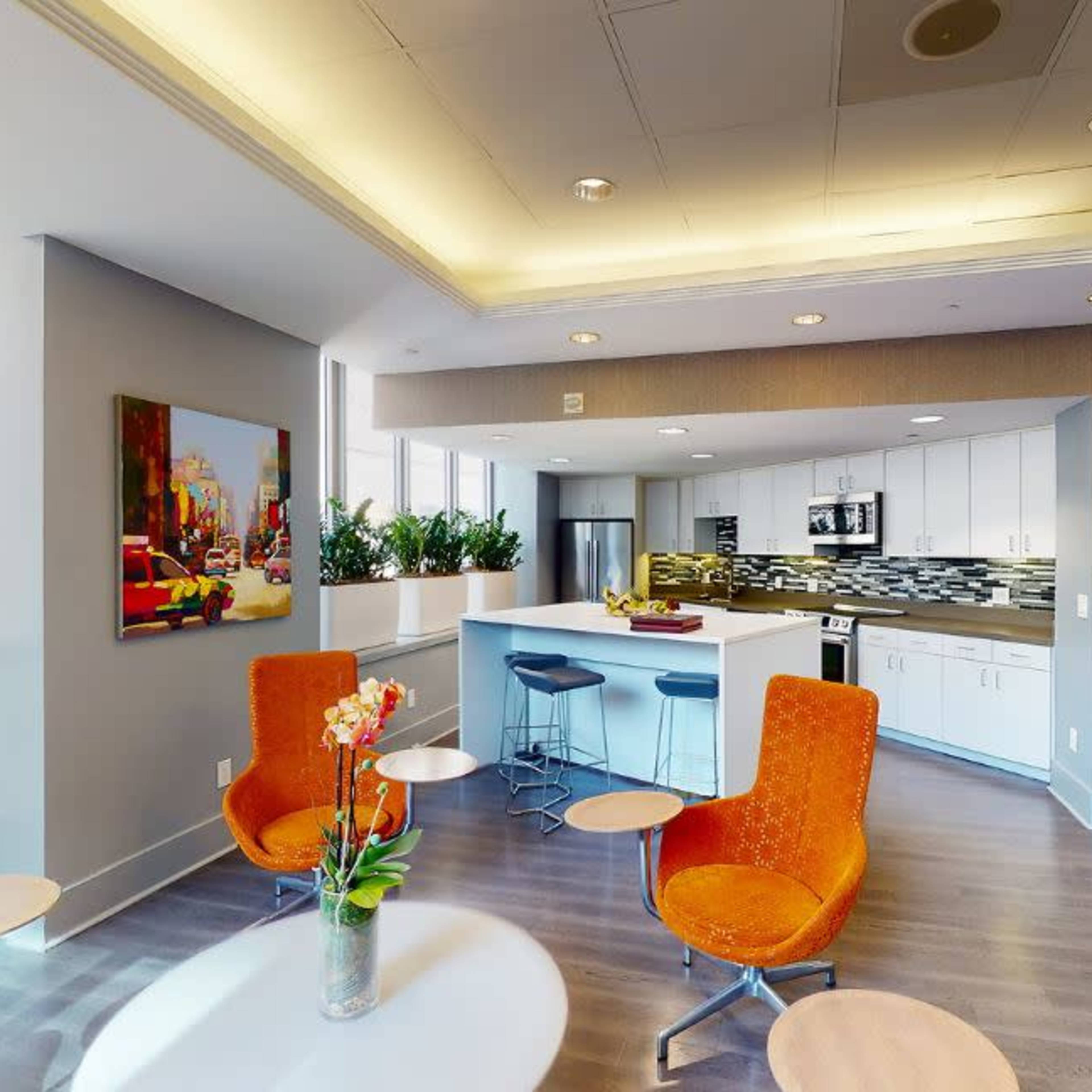 A well-lit lounge area featuring a billiard table, large windows, and modern furnishings.