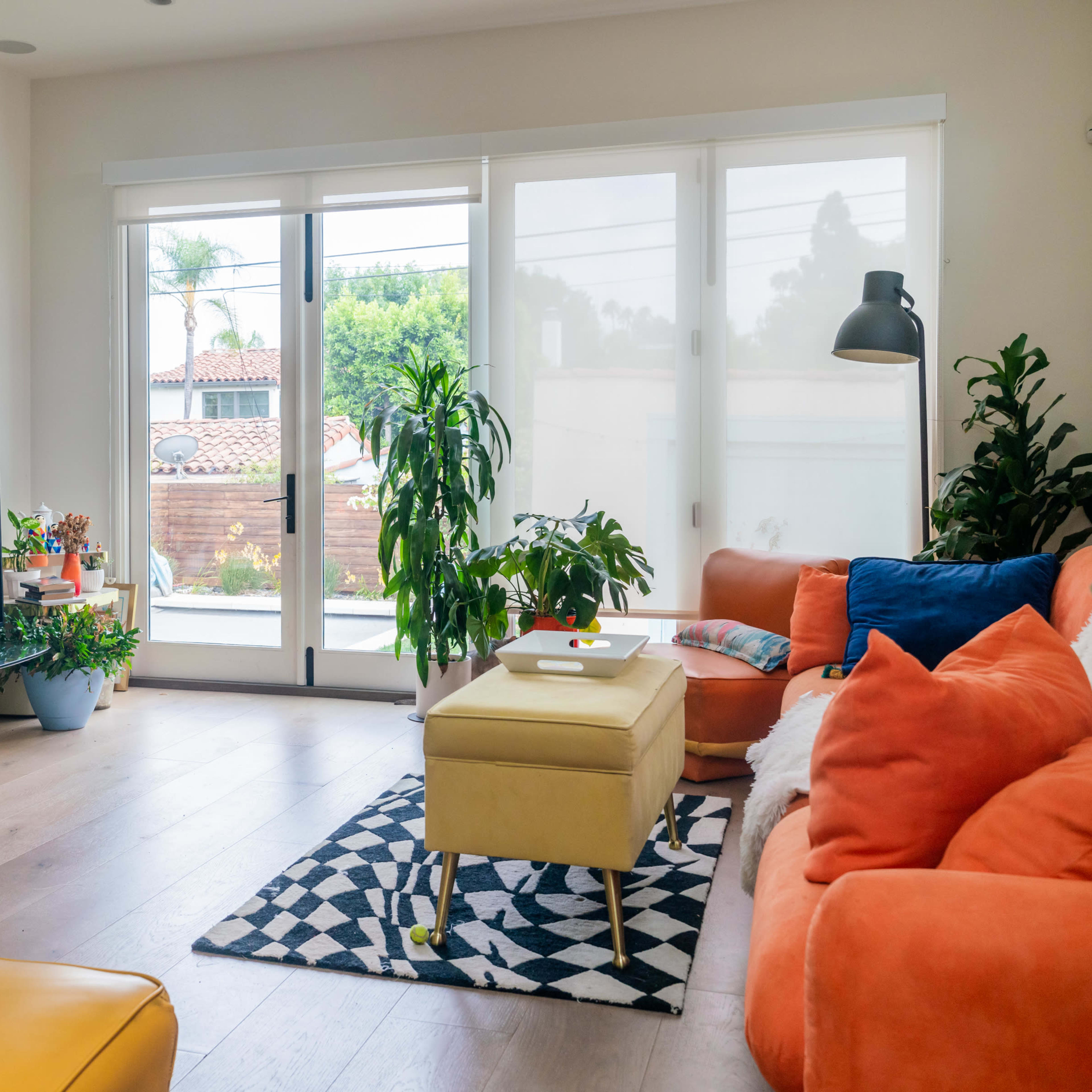 A bright living room featuring a large window, a television, and comfortable seating arranged around a coffee table.