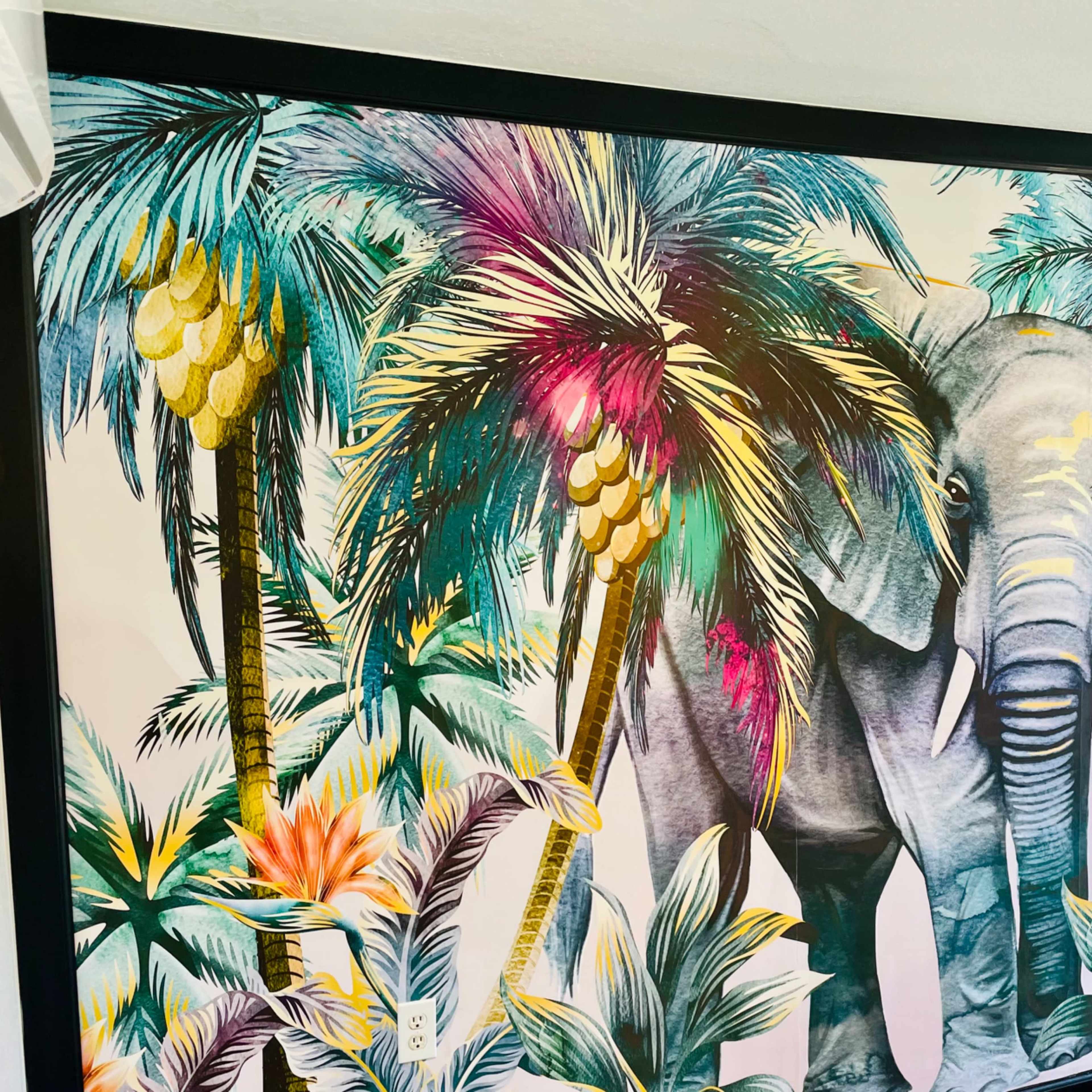 A large mural of an elephant surrounded by vibrant tropical plants and palm trees.