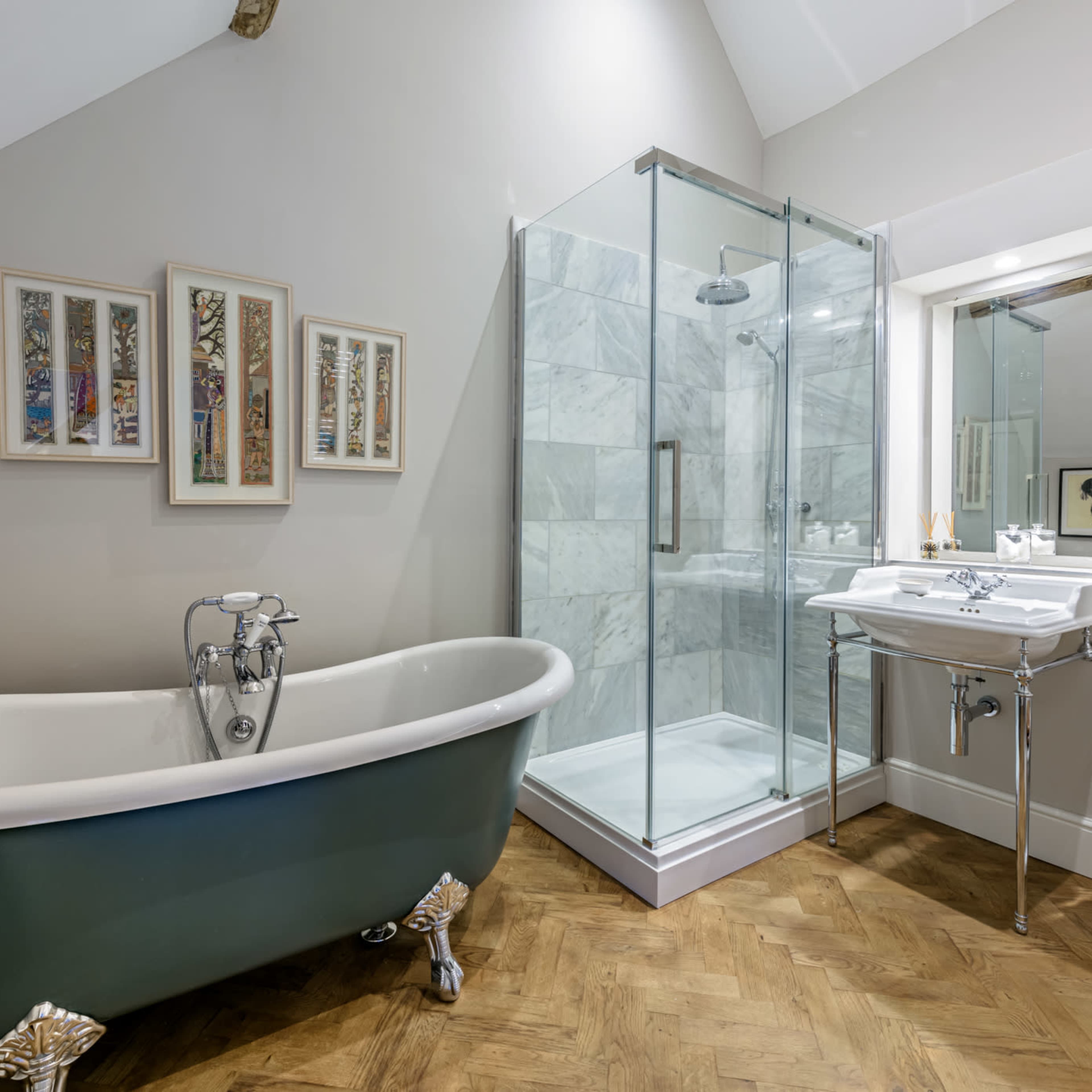 A modern bathroom featuring a freestanding green bathtub, a glass shower enclosure, a sink with a mirror, and a toilet.