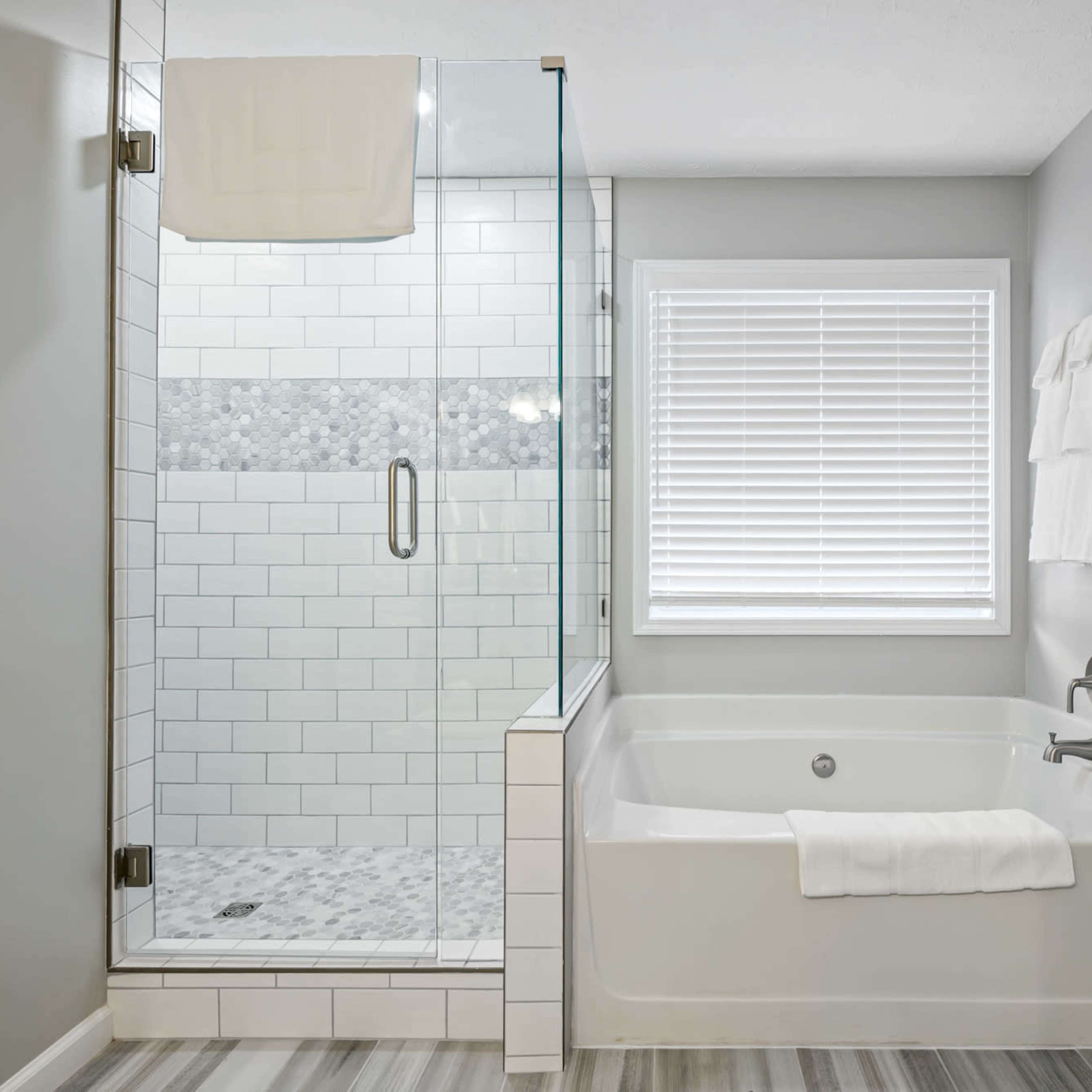 A modern bathroom featuring a glass-enclosed shower and a freestanding bathtub next to it.