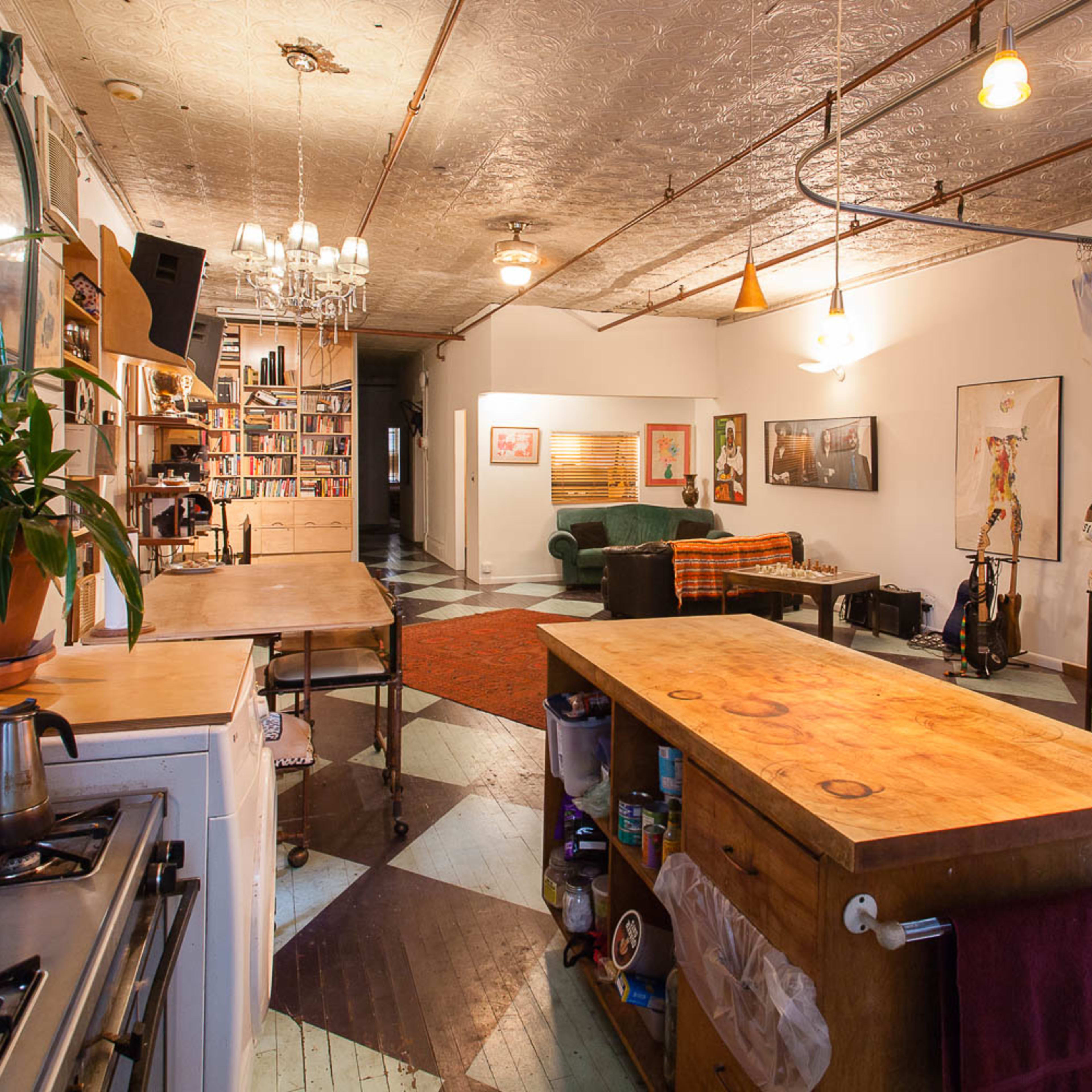 A spacious, open-concept kitchen and living area features wooden countertops, vintage decor, and a cozy seating arrangement.
