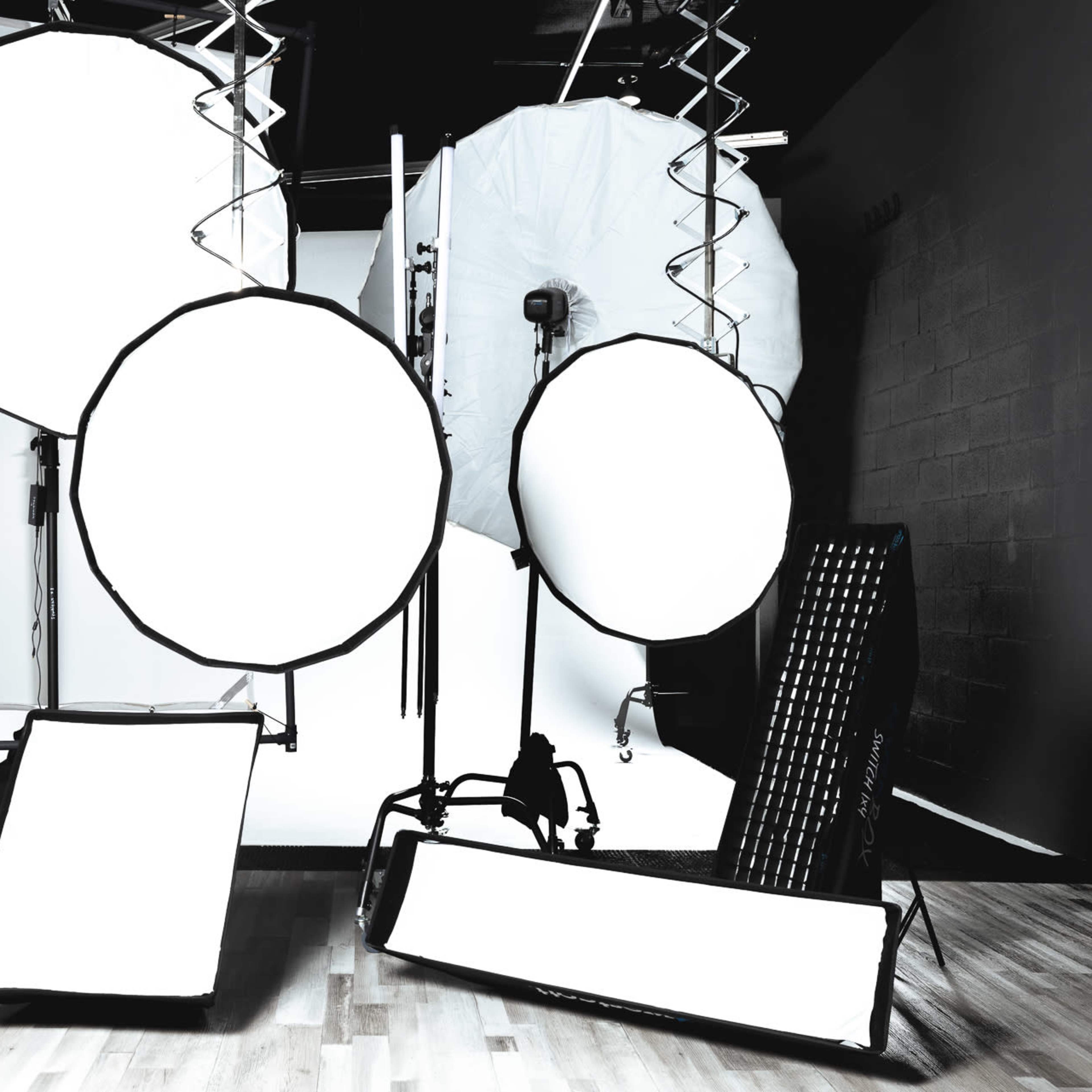Various photography lighting equipment arranged in a studio setting.