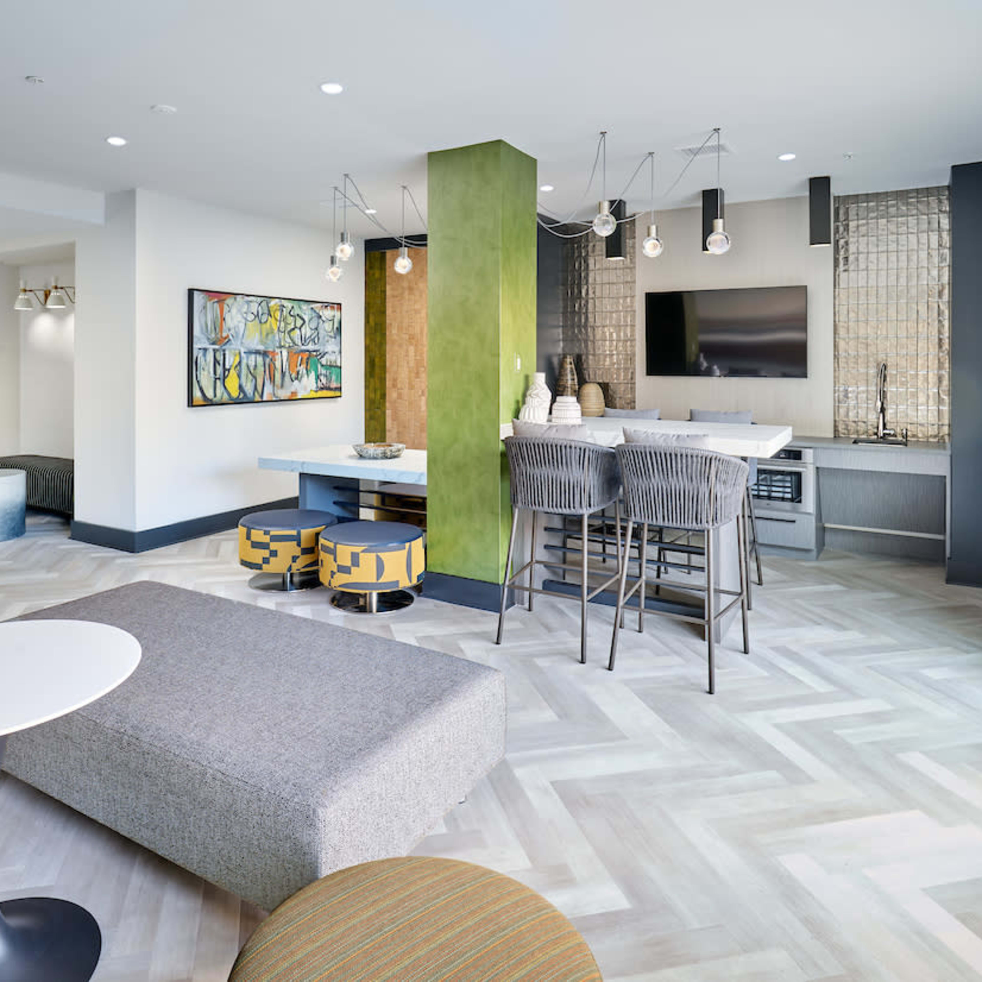 A modern living space with a dining area, a lounge section featuring a low table and seating, and a kitchenette with a stylish decor.