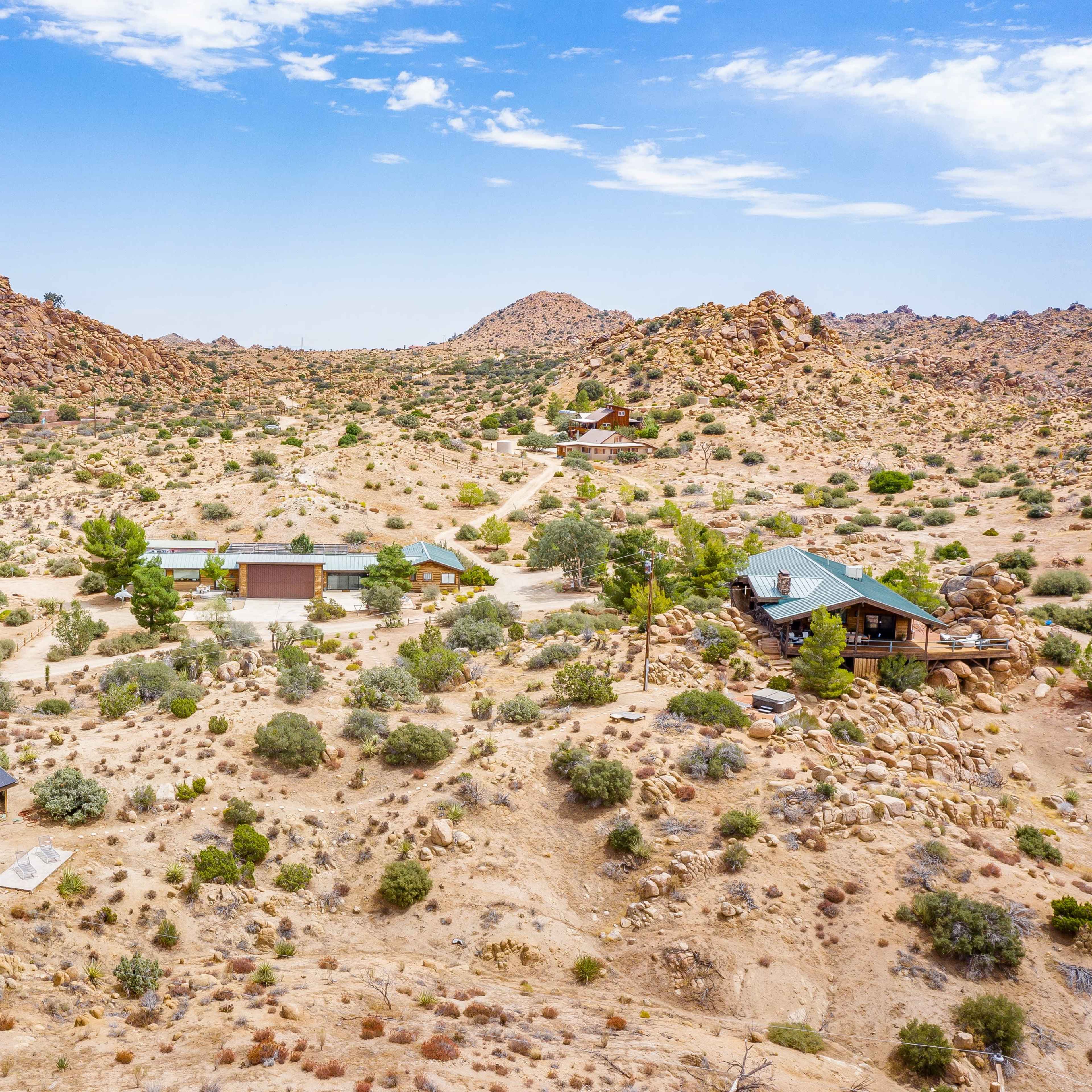 A desert landscape with scattered rocky formations and a few buildings integrated into the terrain.