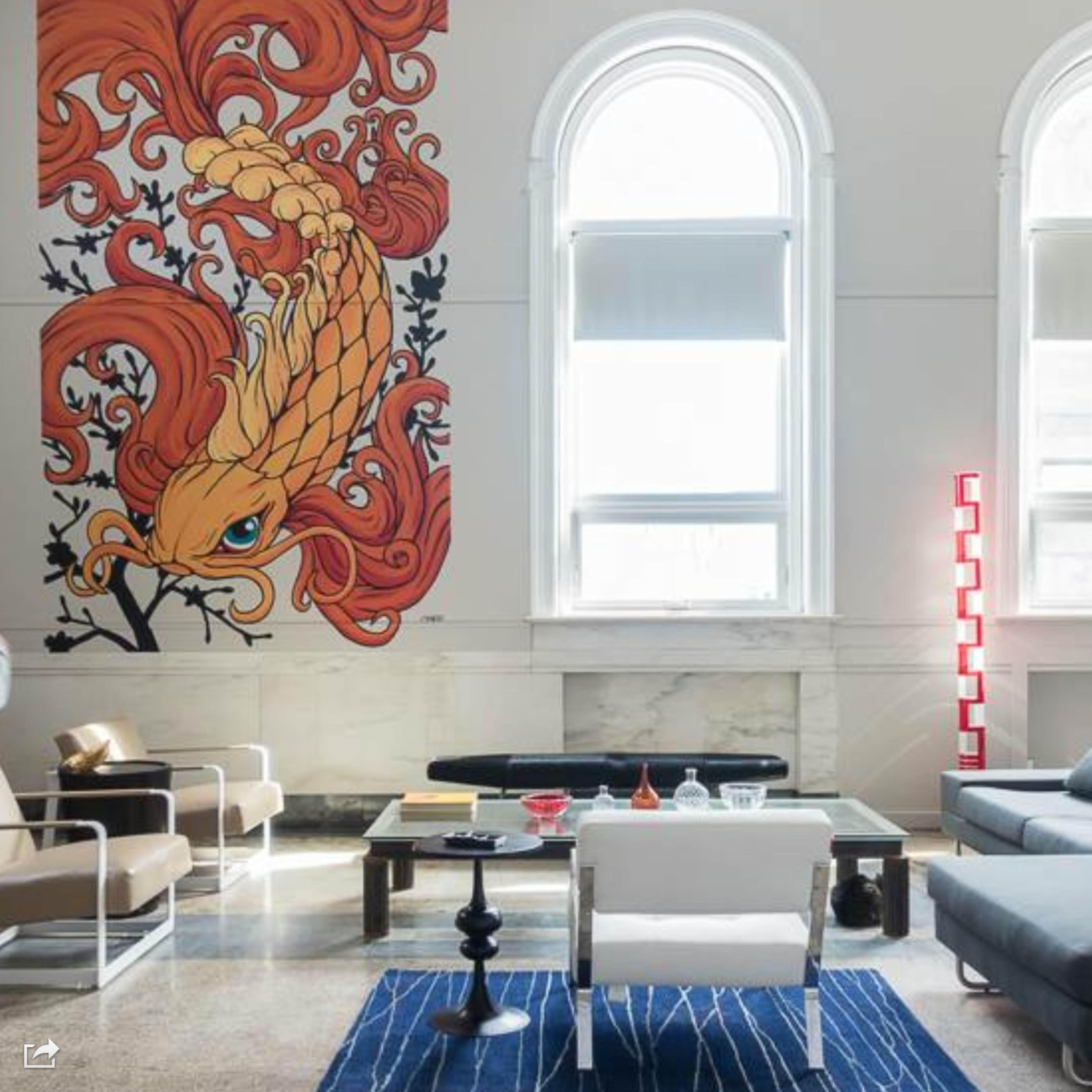 A modern living room featuring a large mural of a stylized orange phoenix on the wall, with a sectional sofa, a coffee table, and a combination of different seating arrangements.