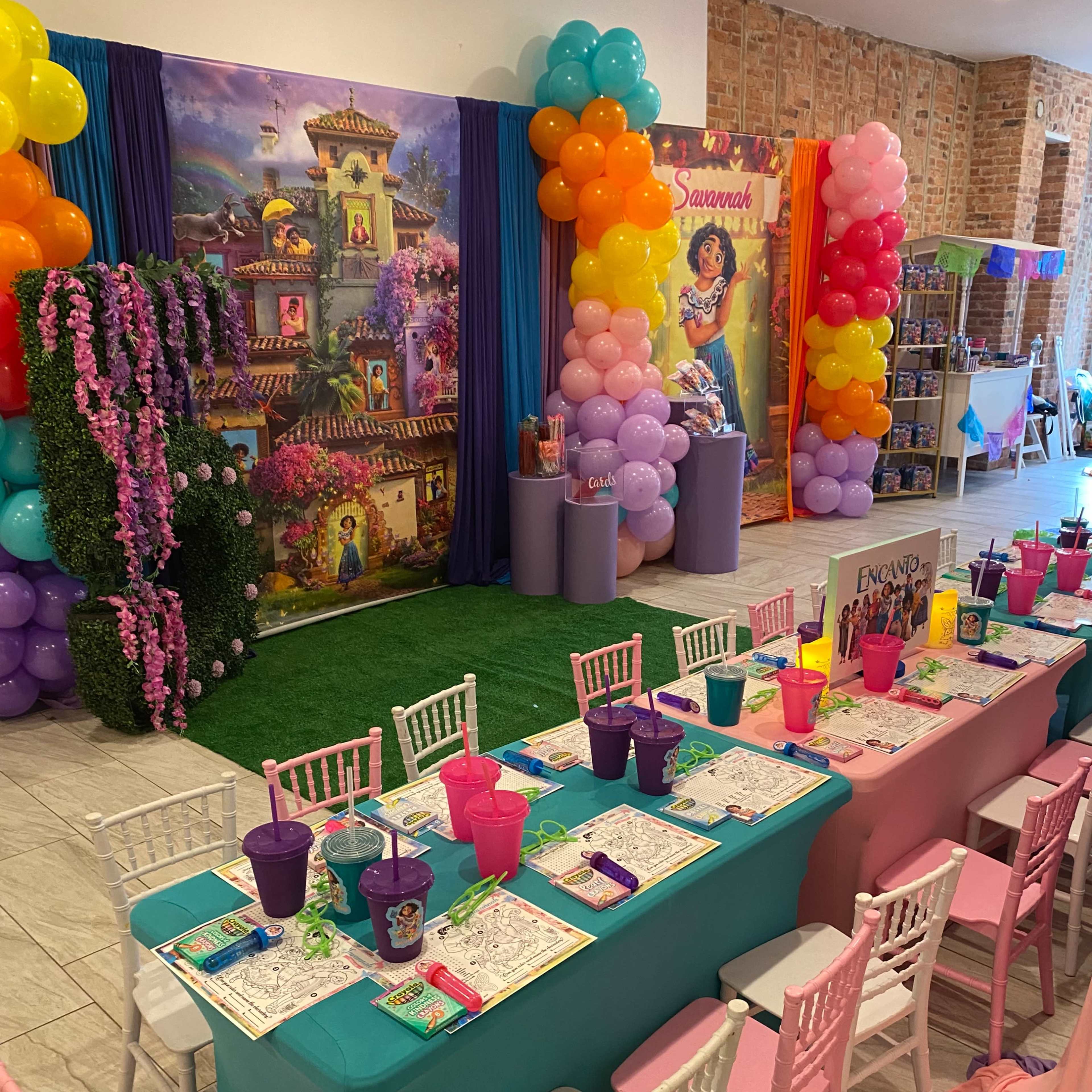 A decorated event space with a vibrant table setup, colorful balloons, and themed decorations for a celebration.