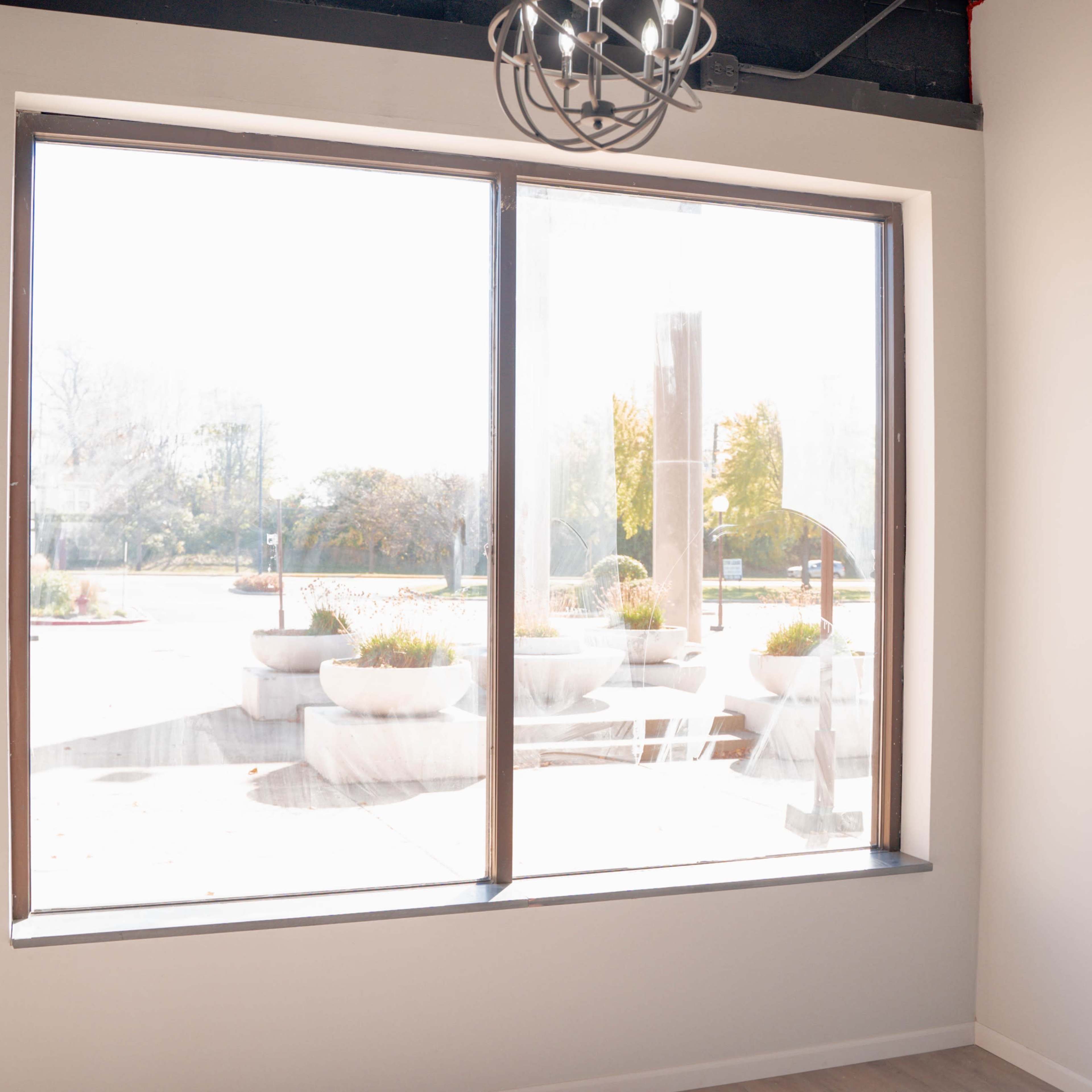 A large window offers a view of outdoor planters and a patio area.