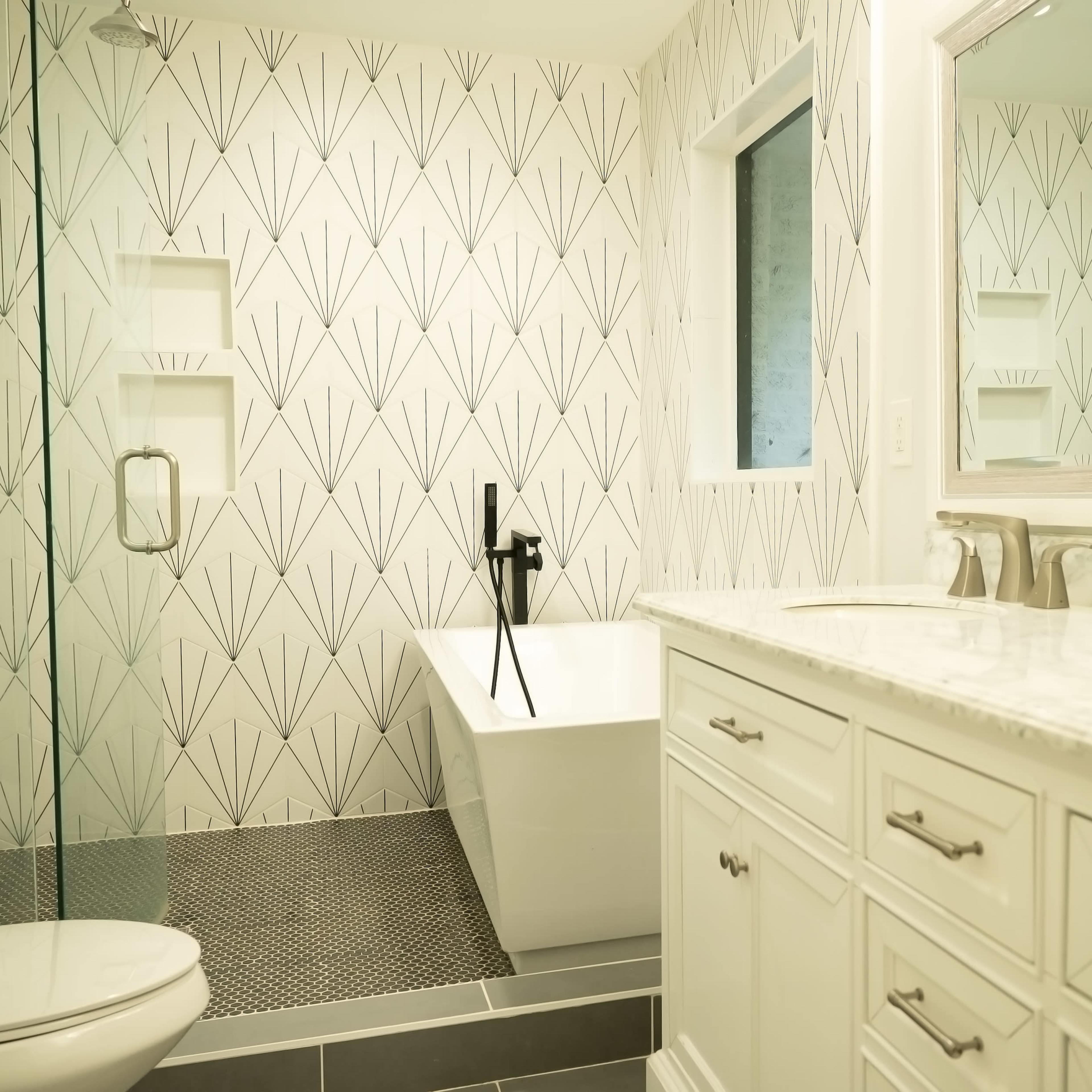 A modern bathroom featuring a freestanding bathtub, a glass shower enclosure, and a vanity with a marble countertop.