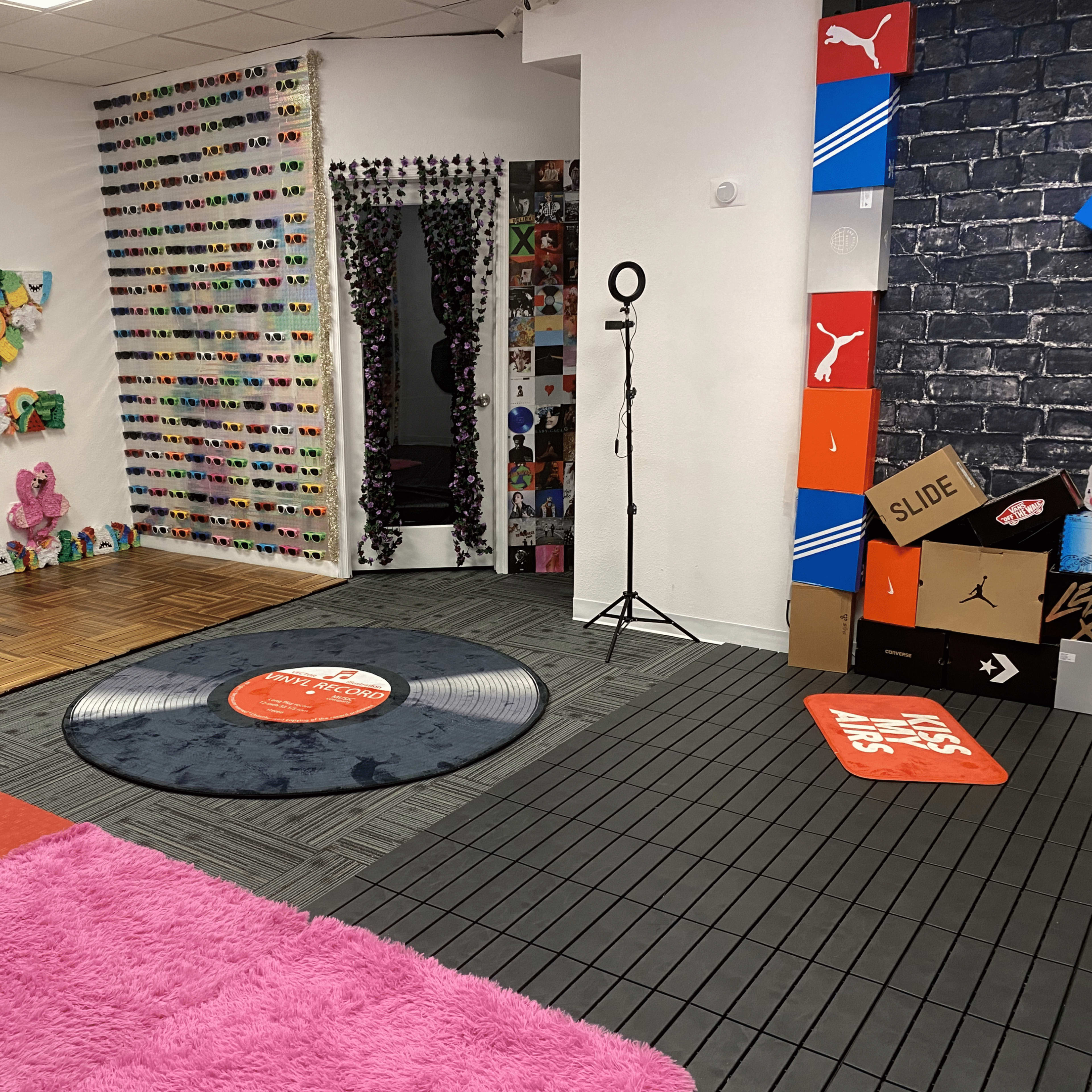 The room features colorful wall decor, a circular carpet in the center, and various patterned mats on the floor.