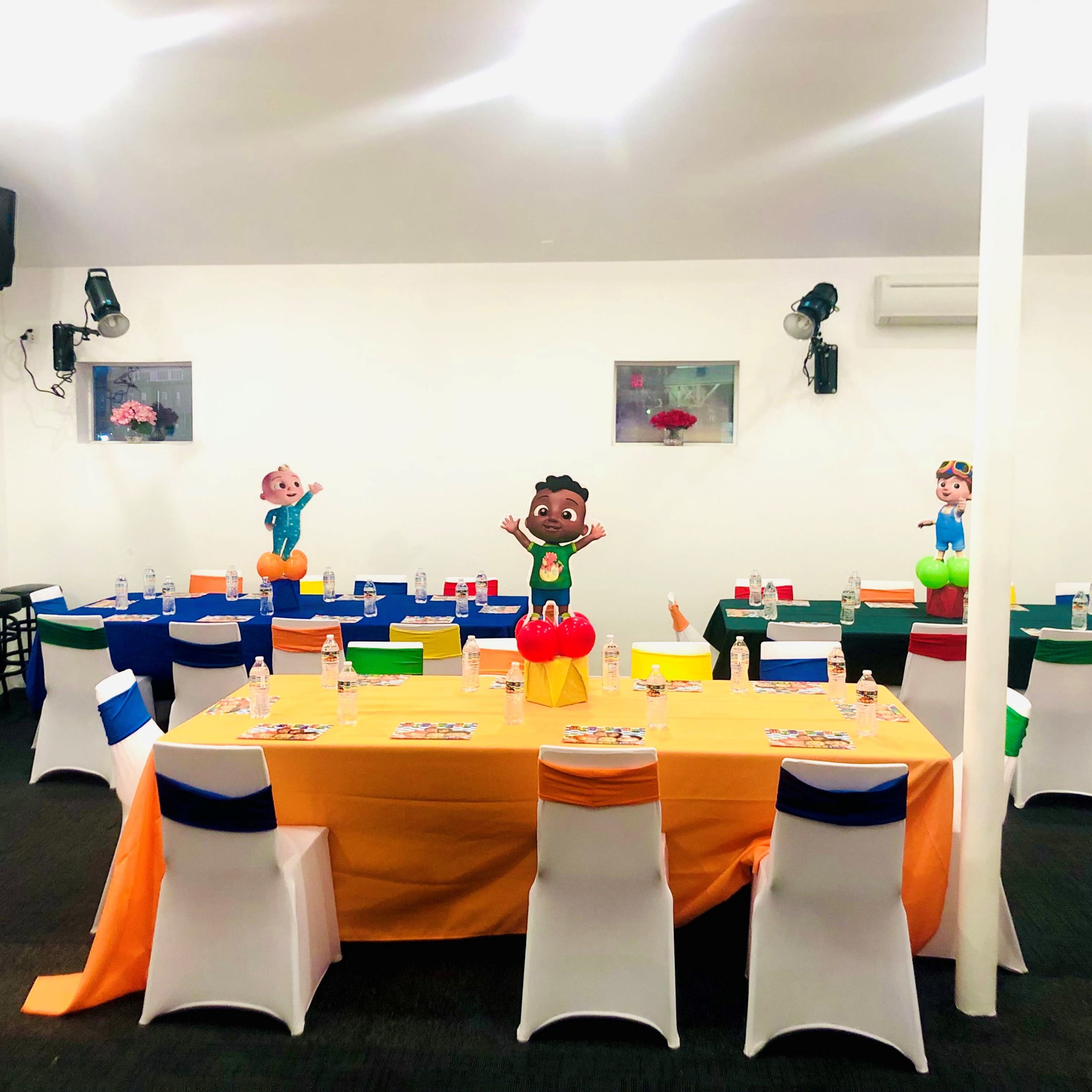 A dining area set up for a children's party, featuring colorful tables adorned with party decorations and cartoon character cutouts.