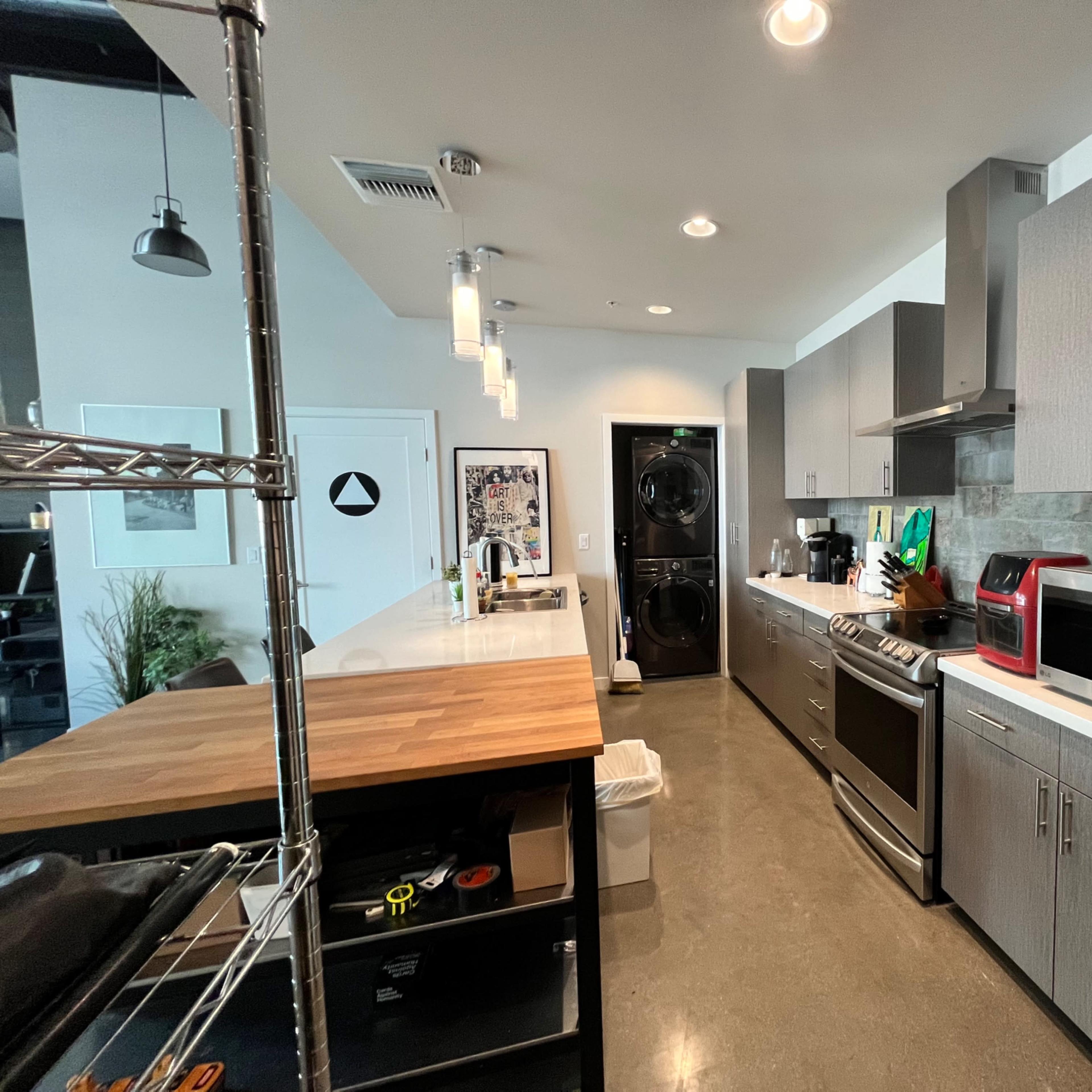 The kitchen features modern cabinetry, stainless steel appliances, and a central island with a wooden countertop.