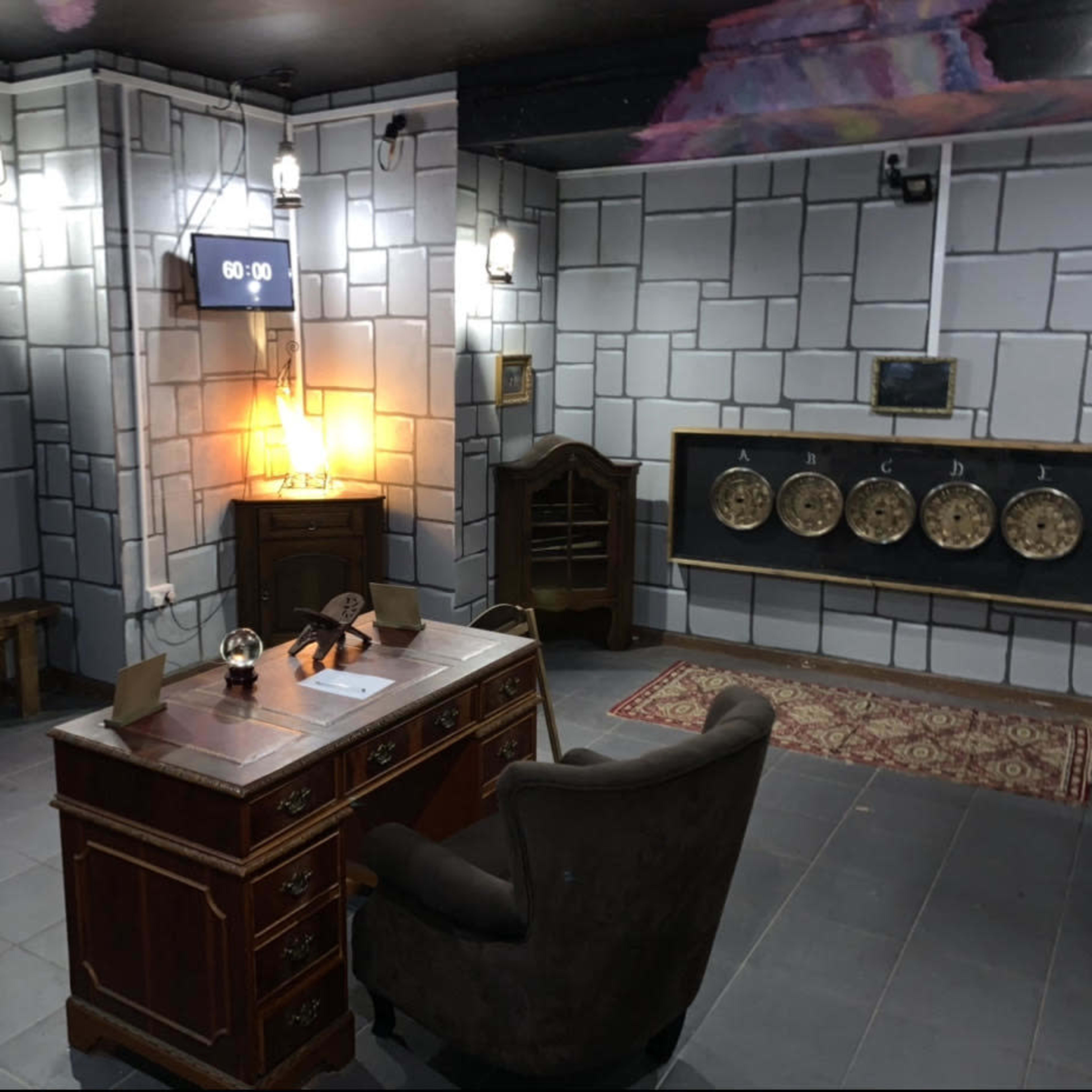 A dimly lit room designed like an old-fashioned office, featuring a wooden desk, a chair, a clock on the wall, and several wall-mounted decorations.